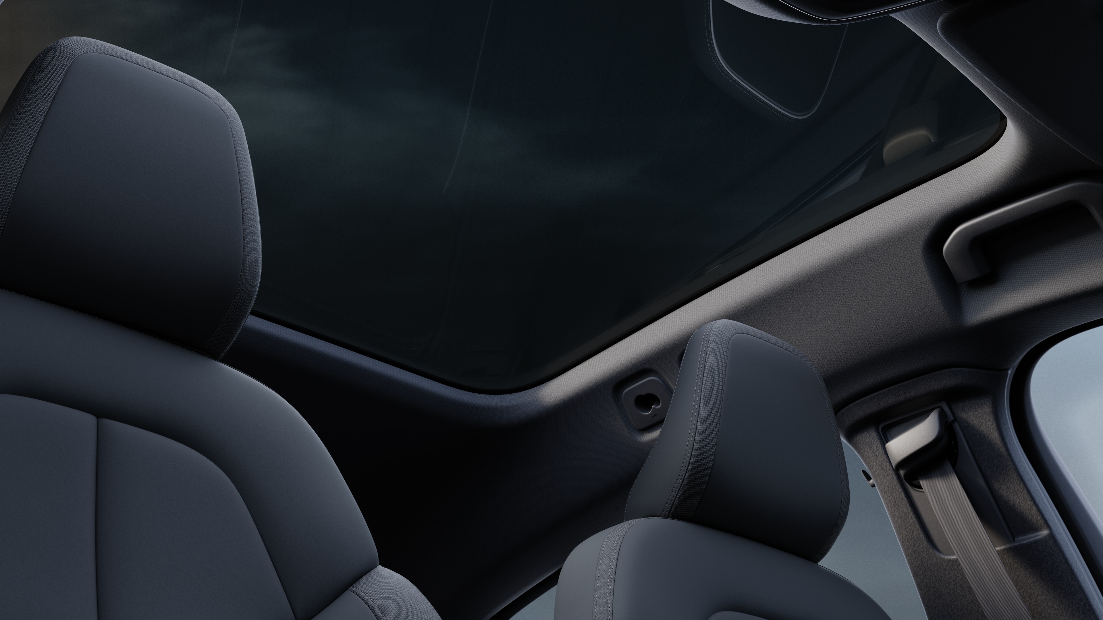 Volvo car interior showing front and rear passenger seats, steering wheel, dashboard, and center console against a plain studio background.
