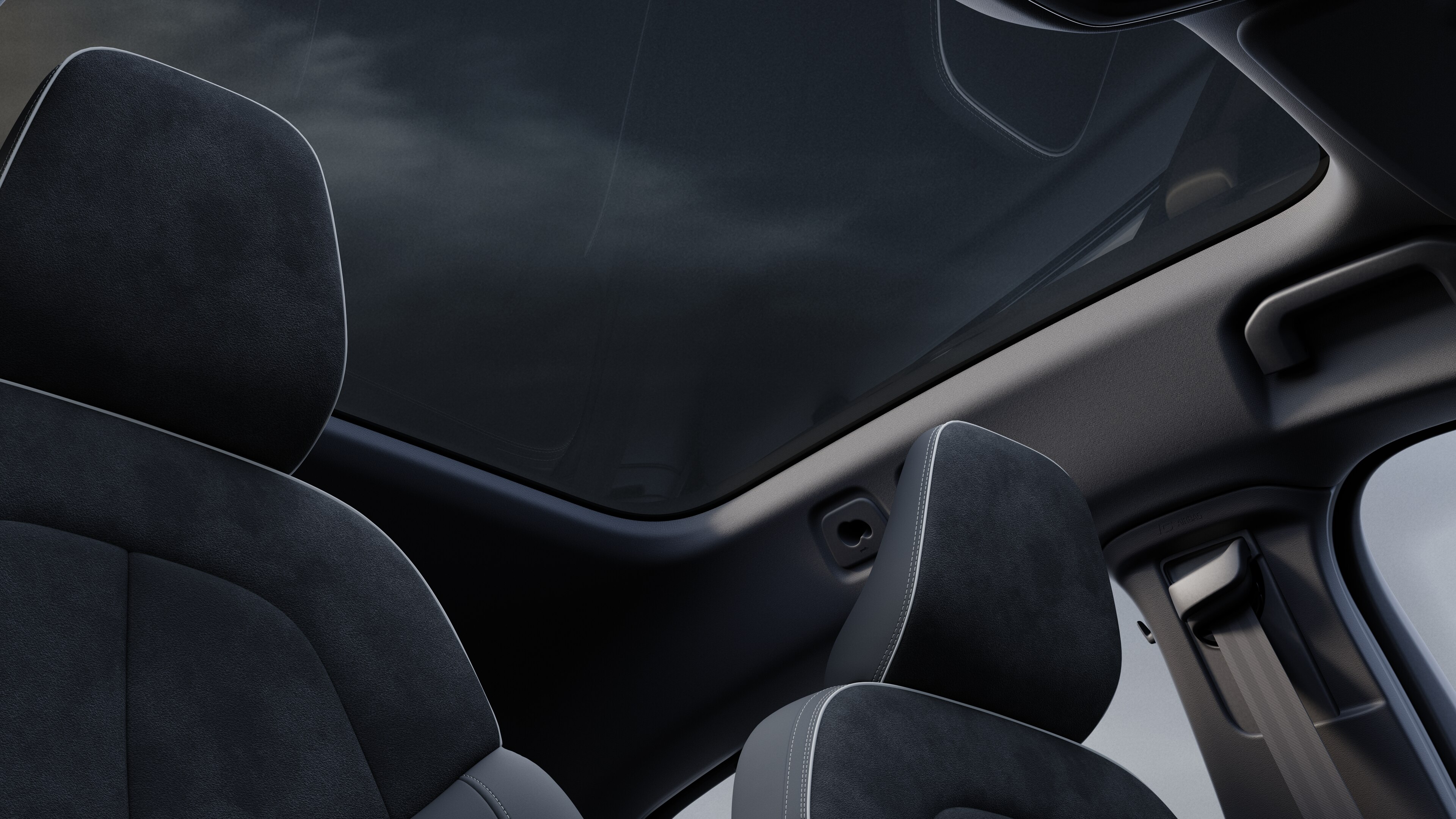 Volvo car interior showing front and rear passenger seats, steering wheel, dashboard, and center console against a plain studio background.