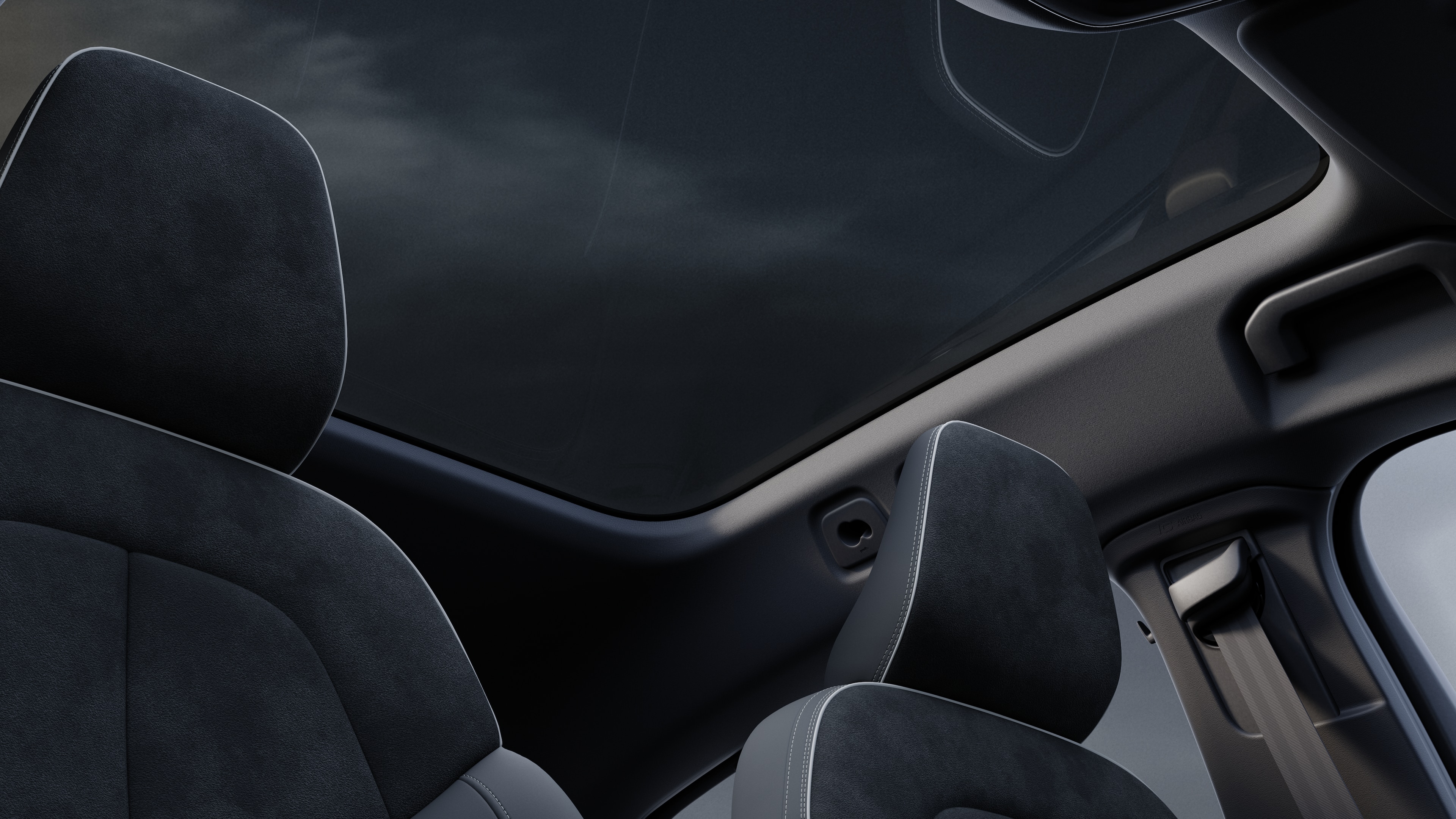 Volvo car interior showing front and rear passenger seats, steering wheel, dashboard, and center console against a plain studio background.