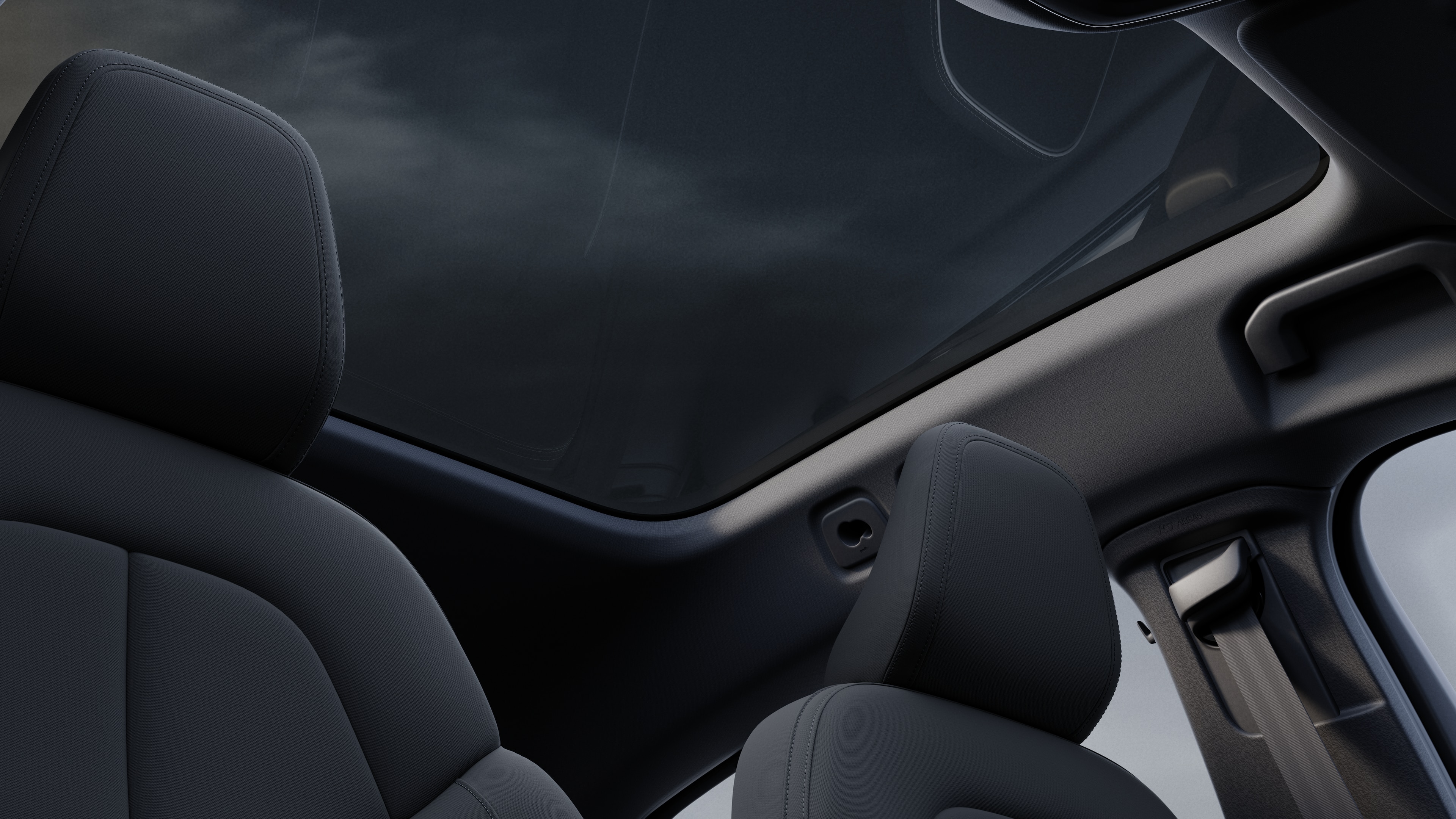 Volvo car interior showing front and rear passenger seats, steering wheel, dashboard, and center console against a plain studio background.