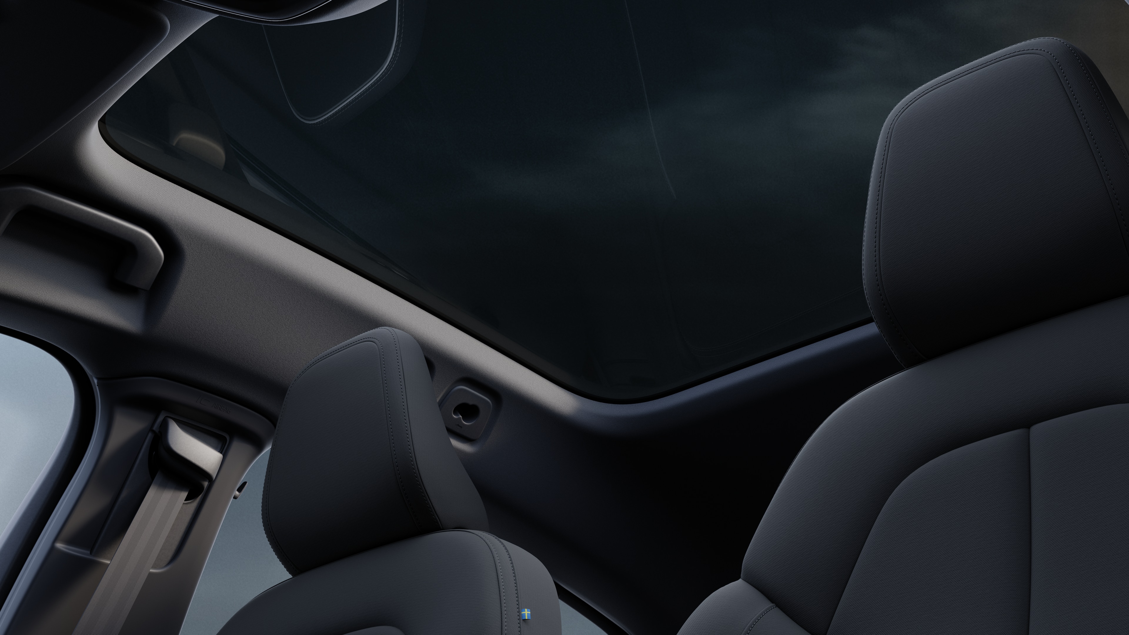 L’intérieur d’une voiture Volvo montrant les sièges passagers avant et arrière, le volant, le tableau de bord et la console centrale sur un fond de studio uni.