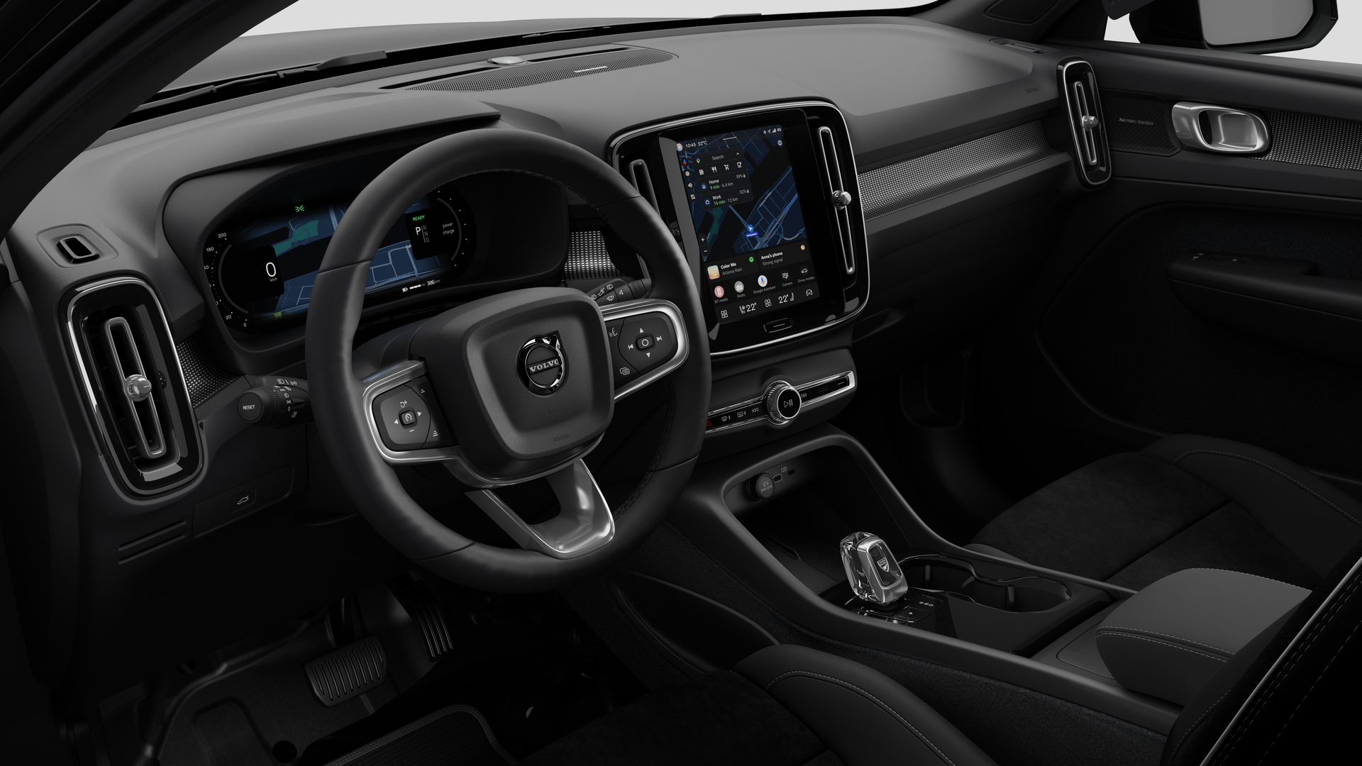Interior view of a Volvo car showing the dashboard, steering wheel, center console, and digital display screen in a plain studio background.