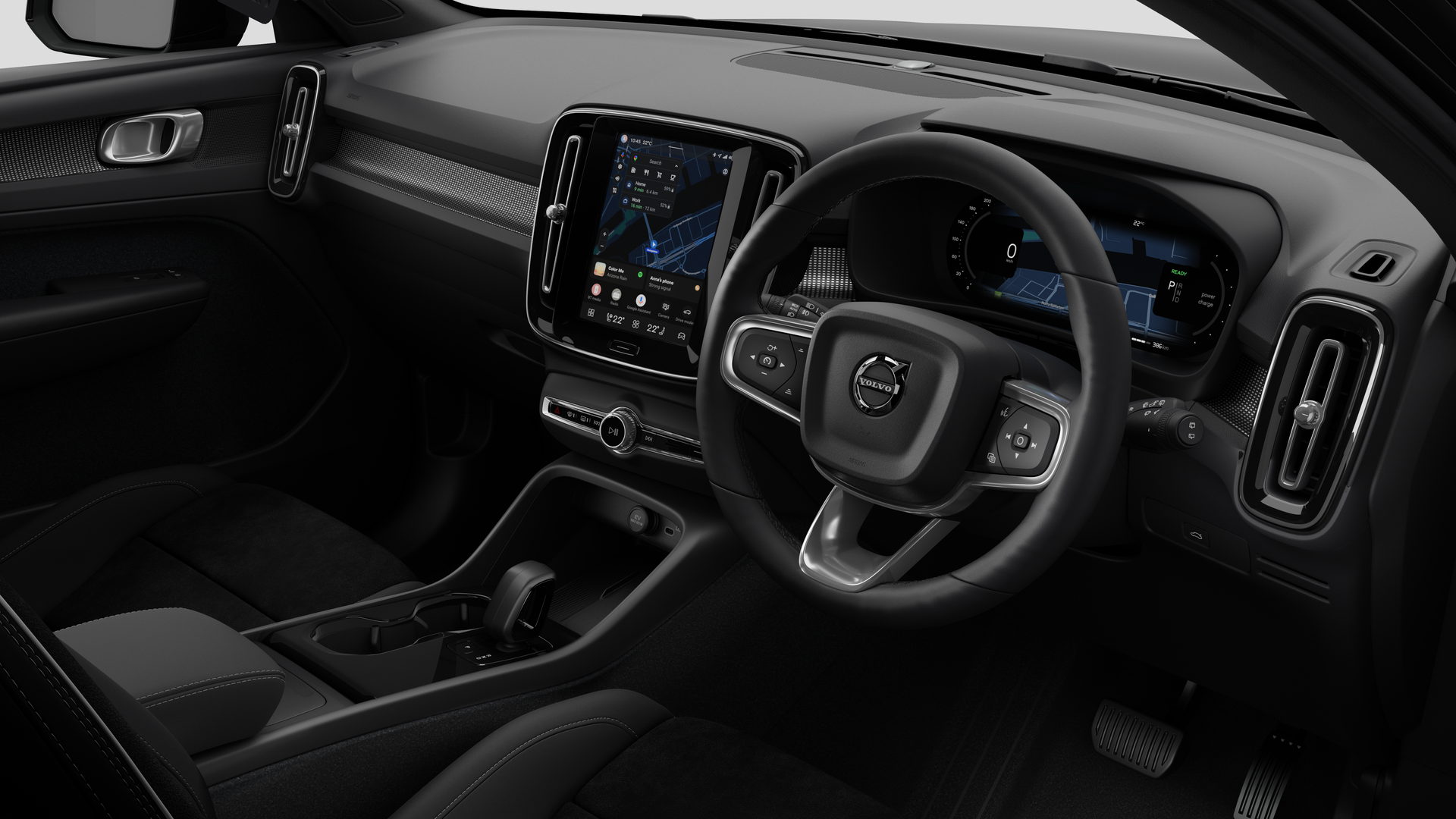 Interior view of a Volvo car showing the dashboard, steering wheel, center console, and digital display screen in a plain studio background.