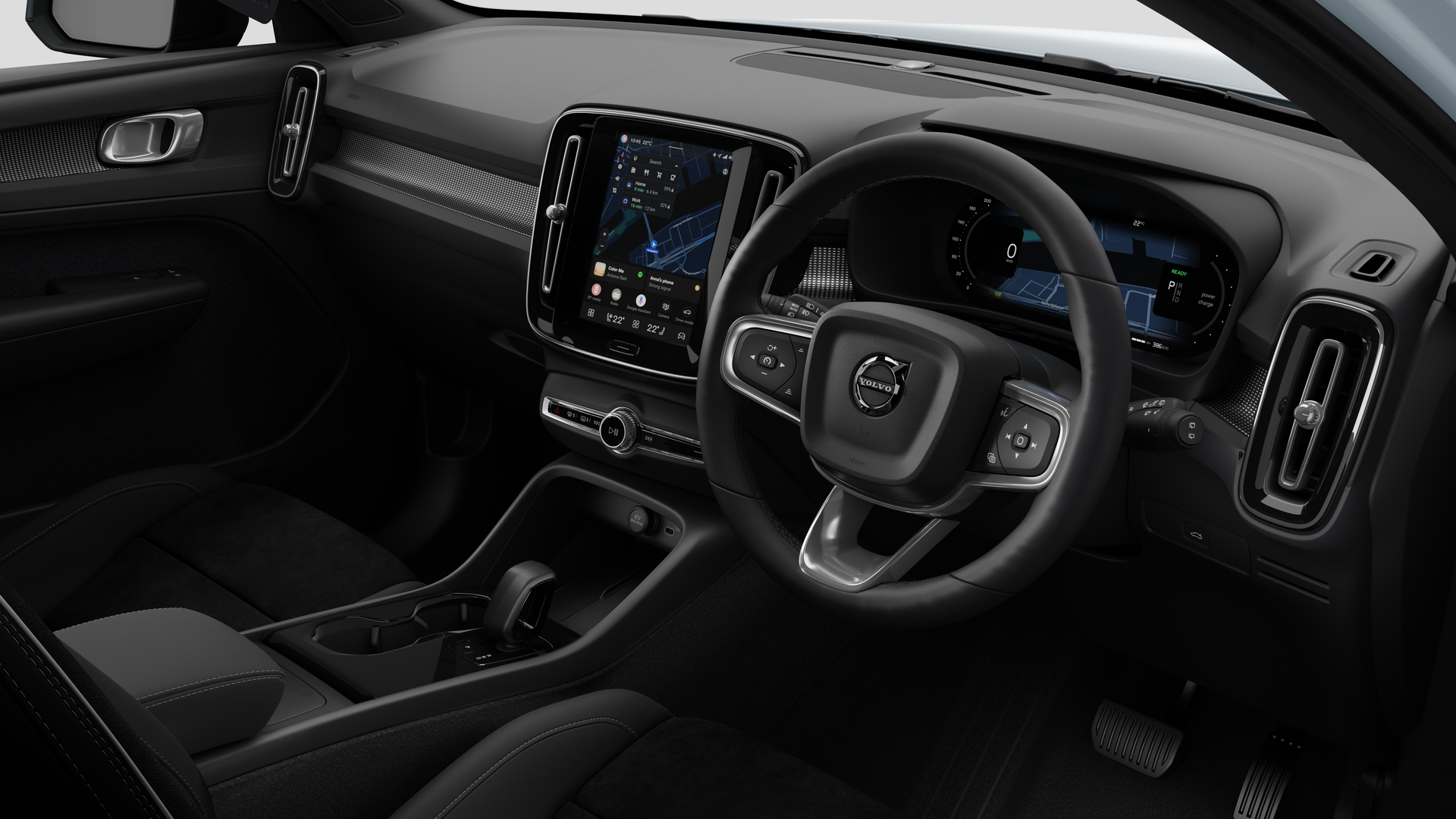 Interior view of a Volvo car showing the dashboard, steering wheel, center console, and digital display screen in a plain studio background.