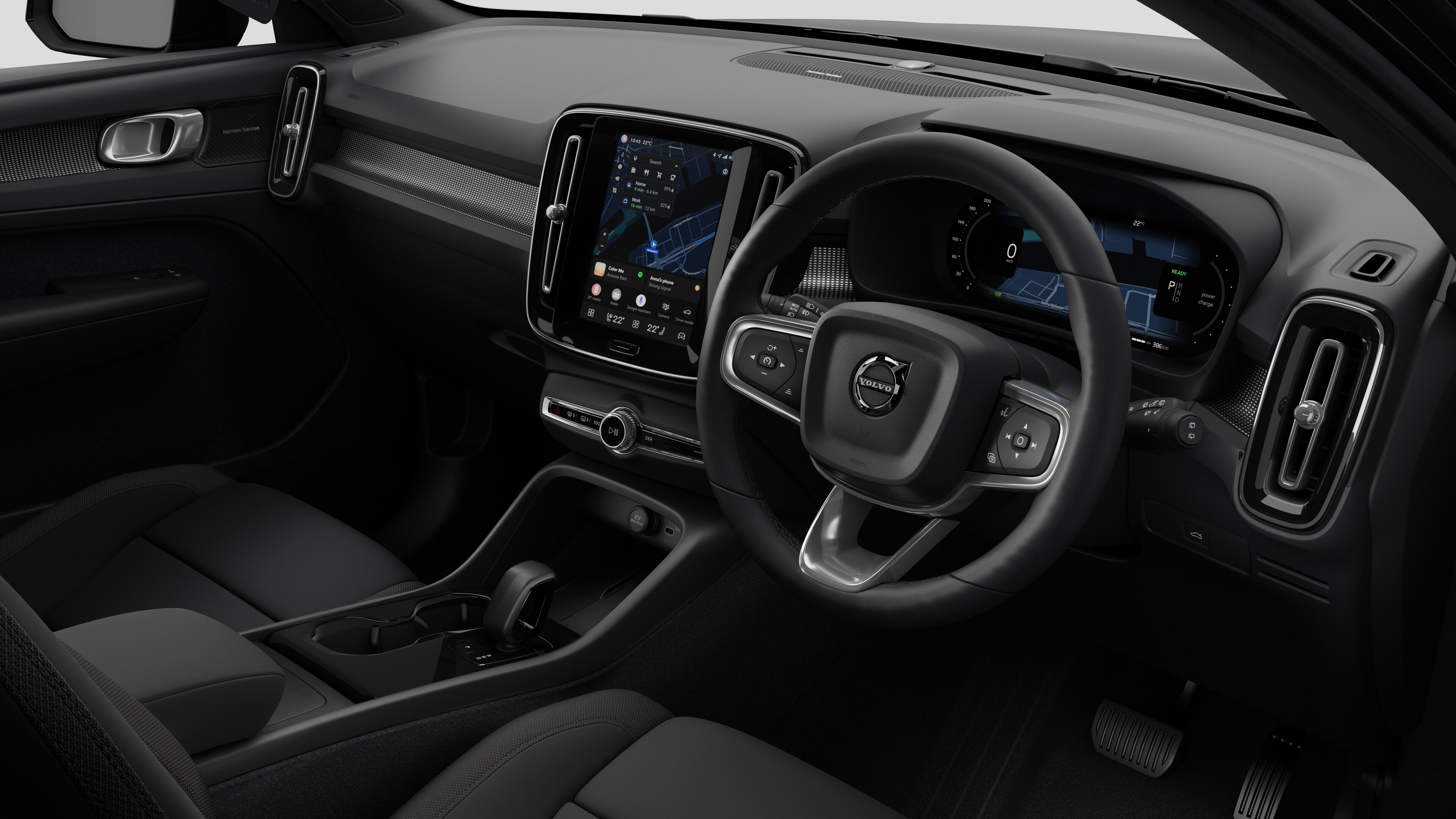 Interior view of a Volvo car showing the dashboard, steering wheel, center console, and digital display screen in a plain studio background.