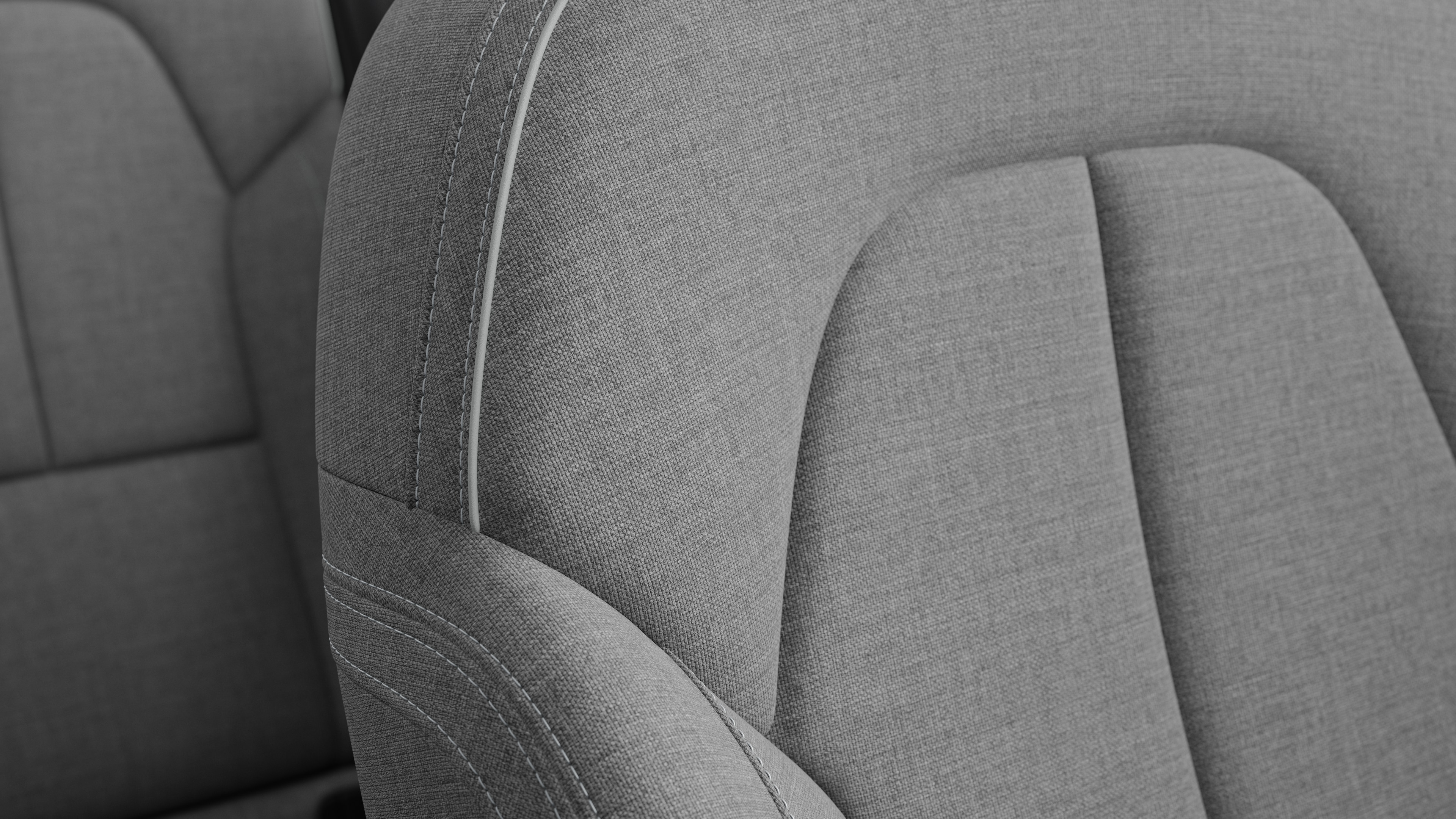 Close-up of Volvo car interior seat detail showing stitching and a small Swedish flag tag.