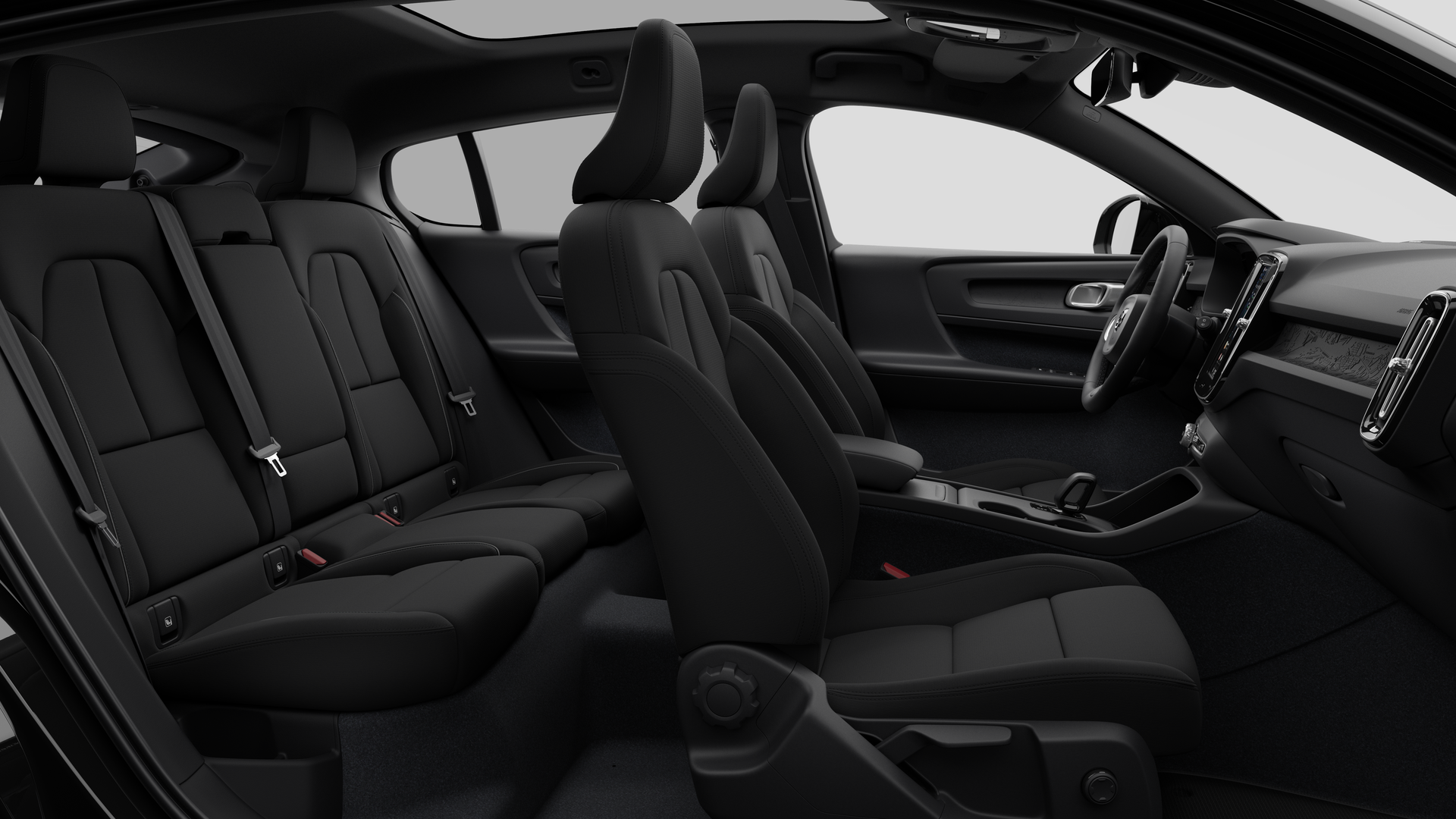 Vue latérale de l’intérieur d’une Volvo montrant les sièges avant, les sièges passager arrière, le volant, le tableau de bord et la console centrale, sur fond de studio.