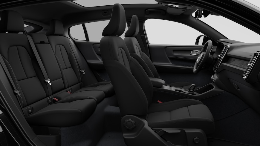 Vista lateral do interior do automóvel Volvo a mostrar os bancos dianteiros, os bancos do passageiro traseiro, o volante, o painel de instrumentos e a consola central, contra um fundo de estúdio simples.