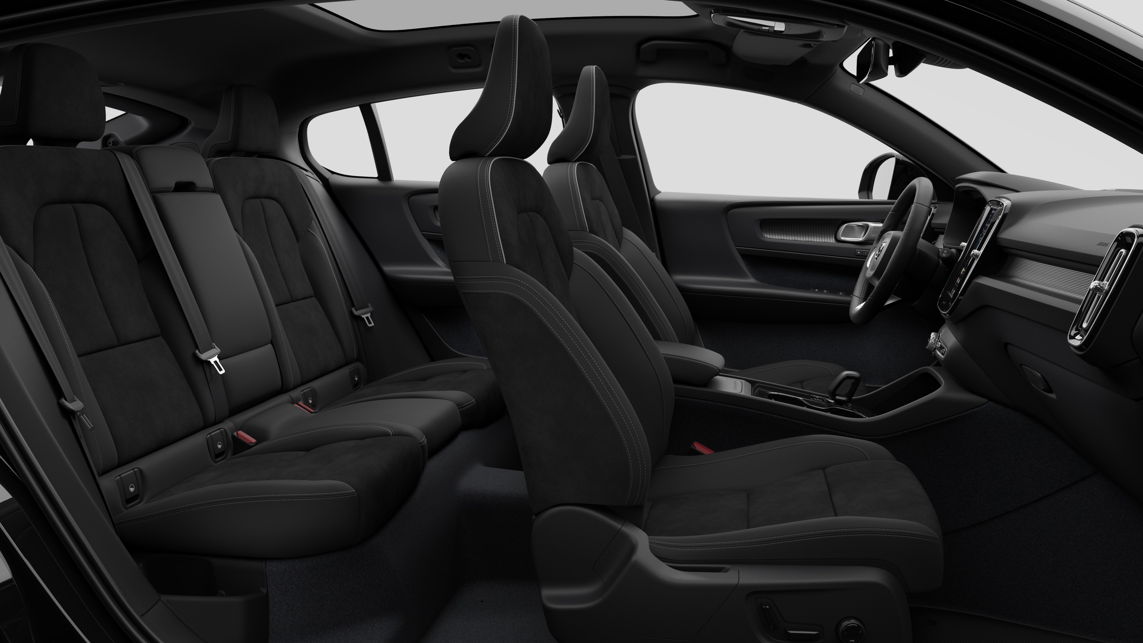 Zijaanzicht van het interieur van een Volvo met de voorstoelen, de passagiersstoelen achterin, het stuur, het dashboard en de middenconsole, tegen een effen studioachtergrond.