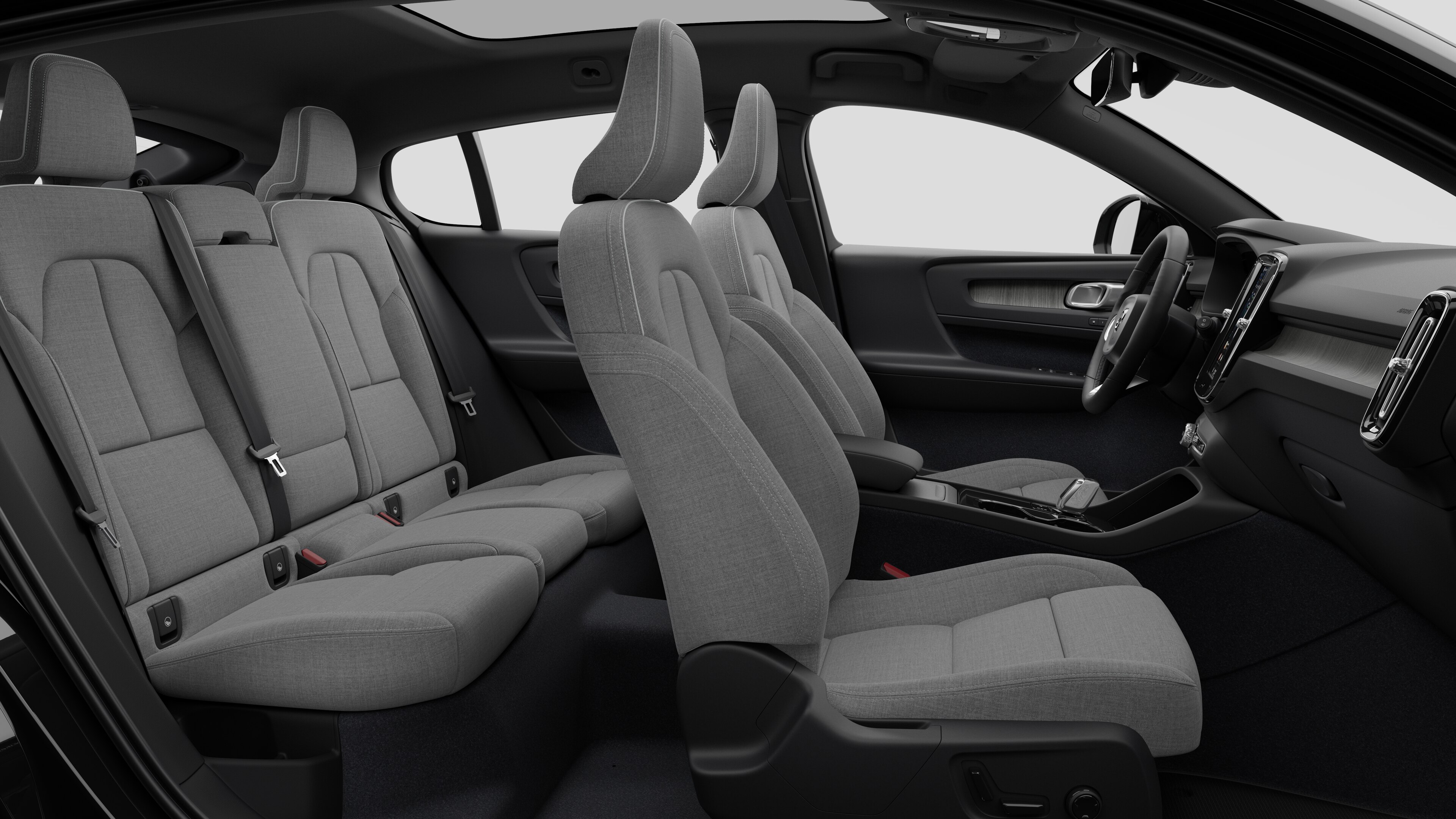 Vista lateral do interior do carro Volvo mostrando os bancos dianteiros, traseiros do passageiro, volante, painel de instrumentos e console central, contra um plano de fundo de estúdio simples.