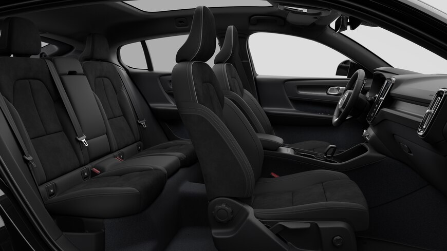 Vista lateral do interior do automóvel Volvo a mostrar os bancos dianteiros, os bancos do passageiro traseiro, o volante, o painel de instrumentos e a consola central, contra um fundo de estúdio simples.