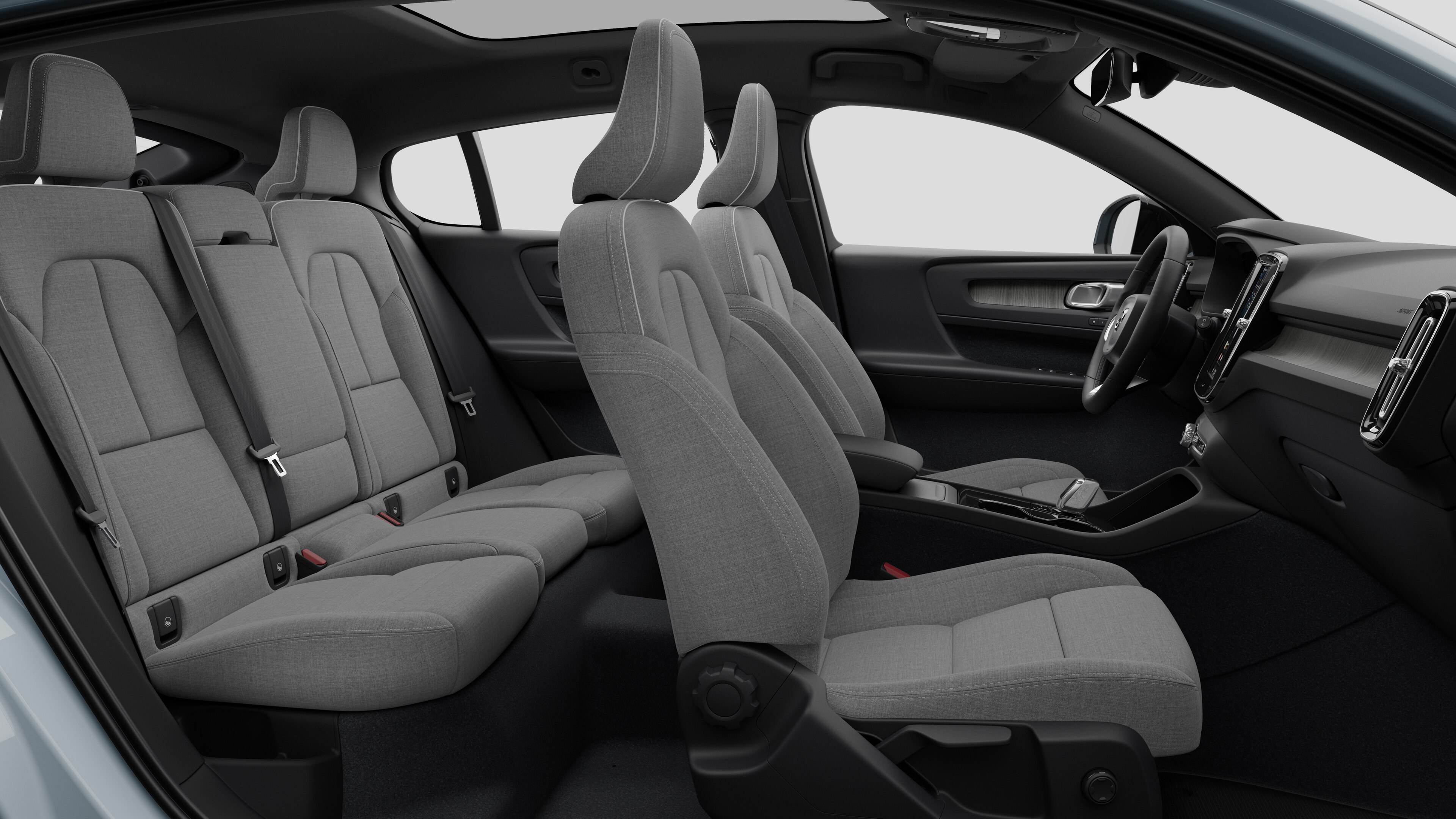 Volvo-bilens interiør set fra siden med forsæder, passagersæder bagi, rat, instrumentbræt og midterkonsol mod almindelig studiebaggrund.