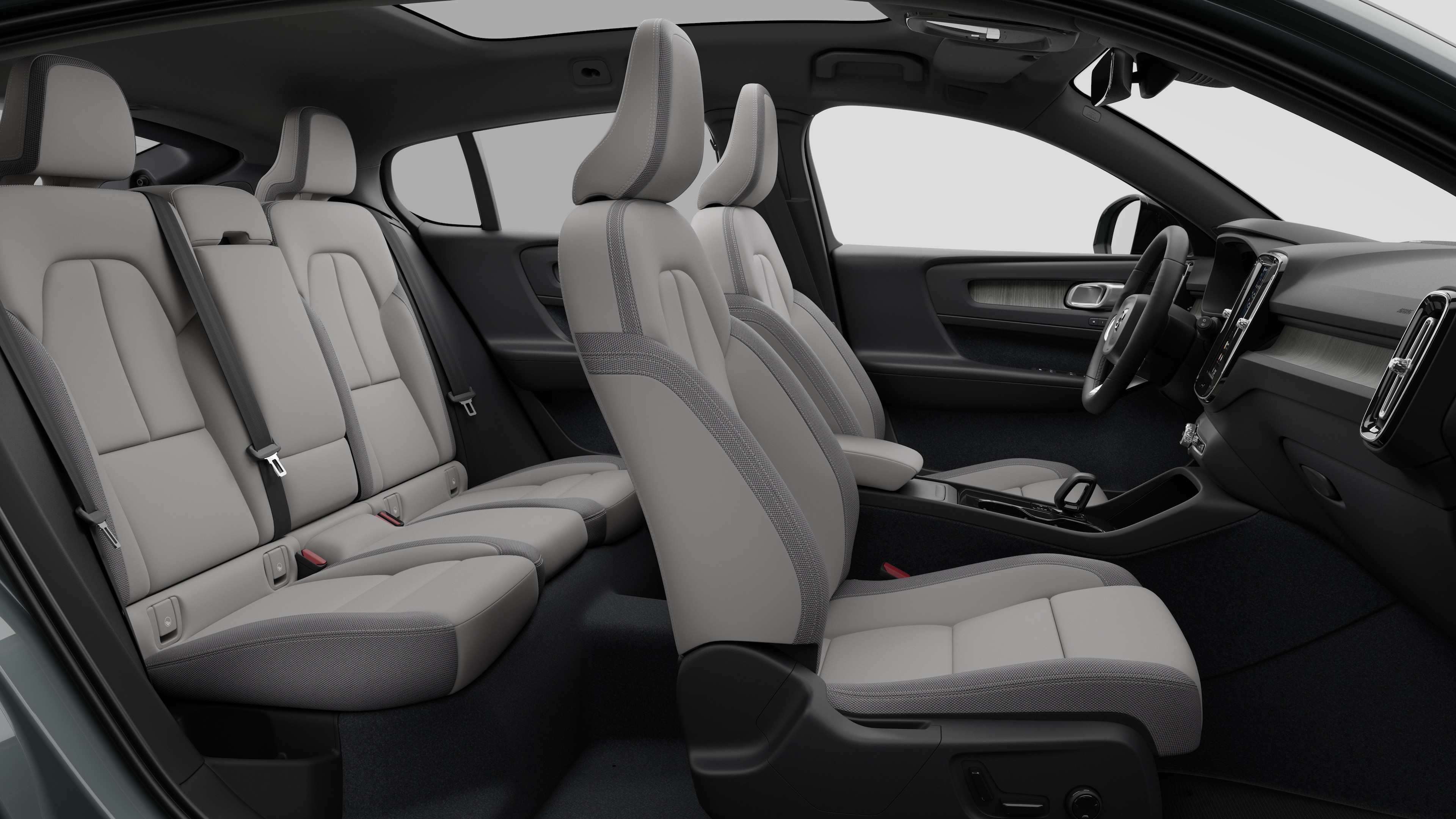 Vue latérale de l’intérieur d’une voiture Volvo présentant les sièges avant, les sièges passager arrière, le volant, le tableau de bord et la console centrale, sur fond de studio uni.