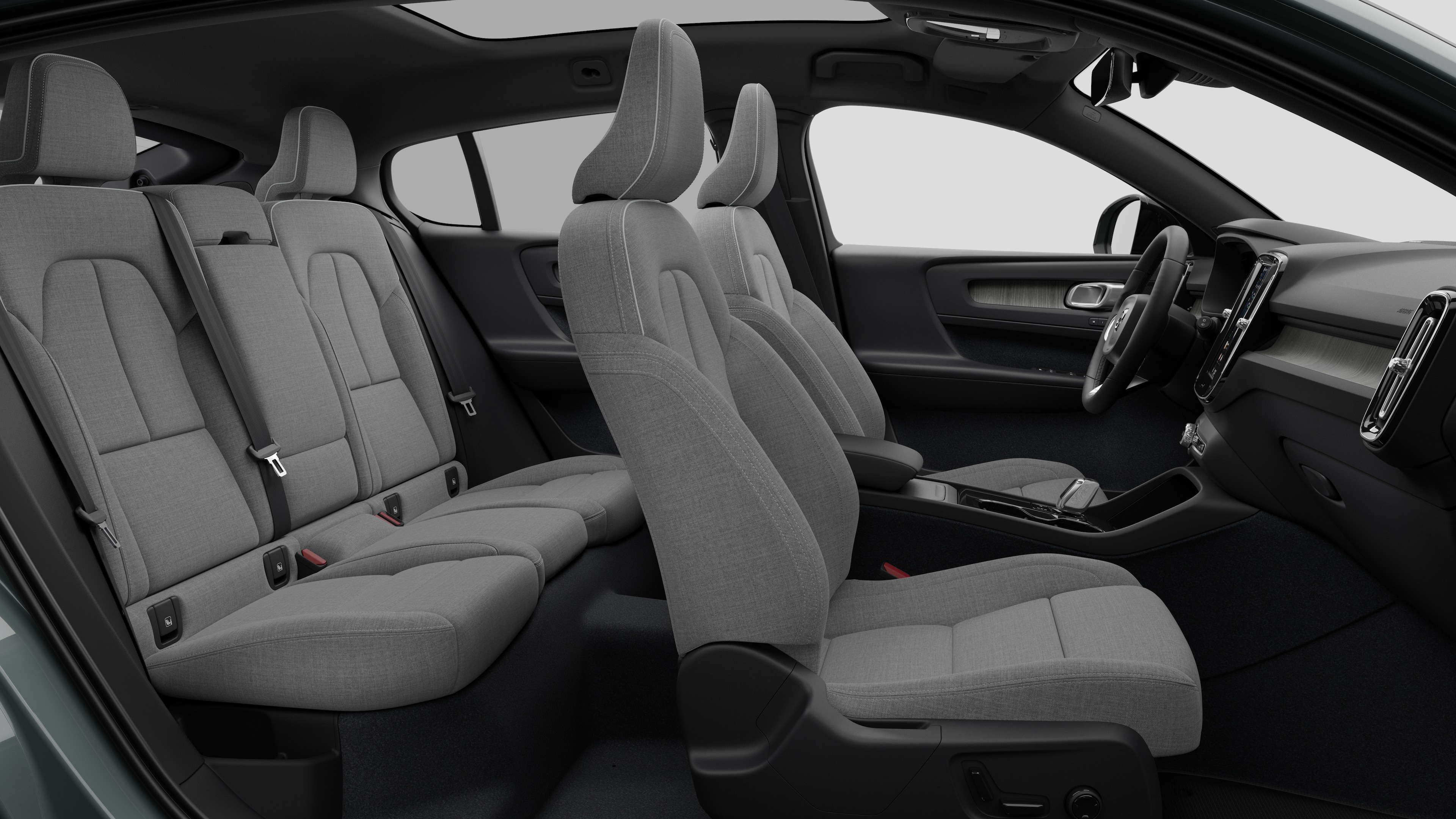 Vue latérale de l’intérieur d’une voiture Volvo présentant les sièges avant, les sièges passager arrière, le volant, le tableau de bord et la console centrale, sur fond de studio uni.