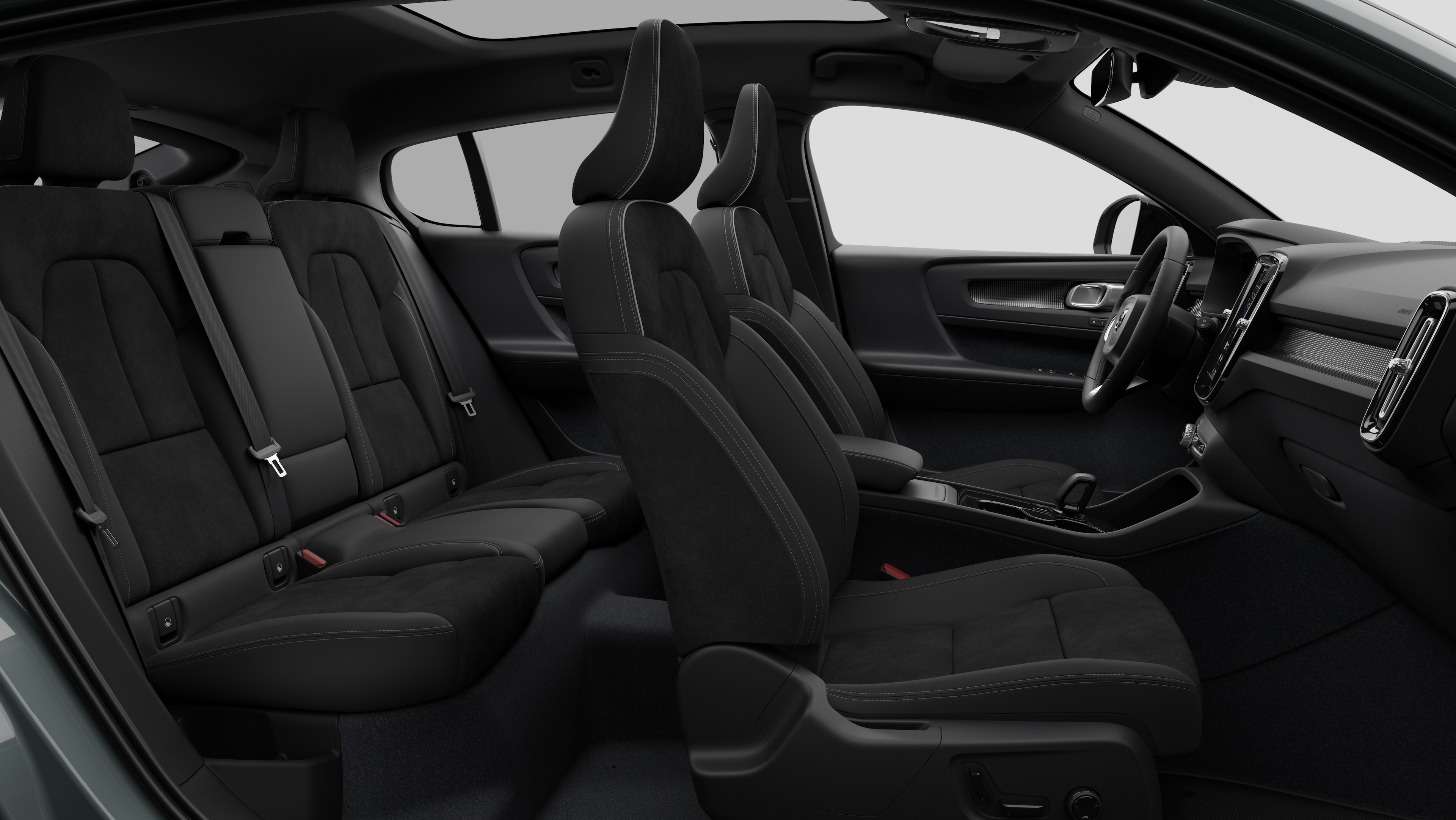 Vue latérale de l’intérieur d’une voiture Volvo présentant les sièges avant, les sièges passager arrière, le volant, le tableau de bord et la console centrale, sur fond de studio uni.