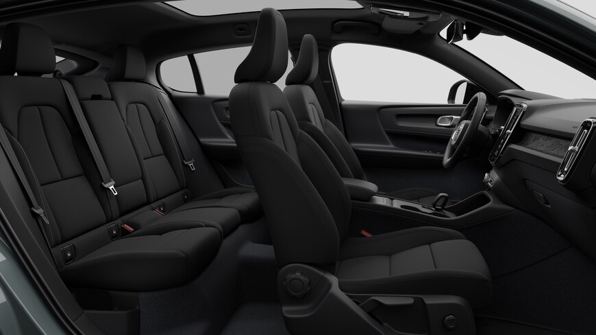 Vista lateral do interior do automóvel Volvo a mostrar os bancos dianteiros, os bancos do passageiro traseiro, o volante, o painel de instrumentos e a consola central, contra um fundo de estúdio simples.