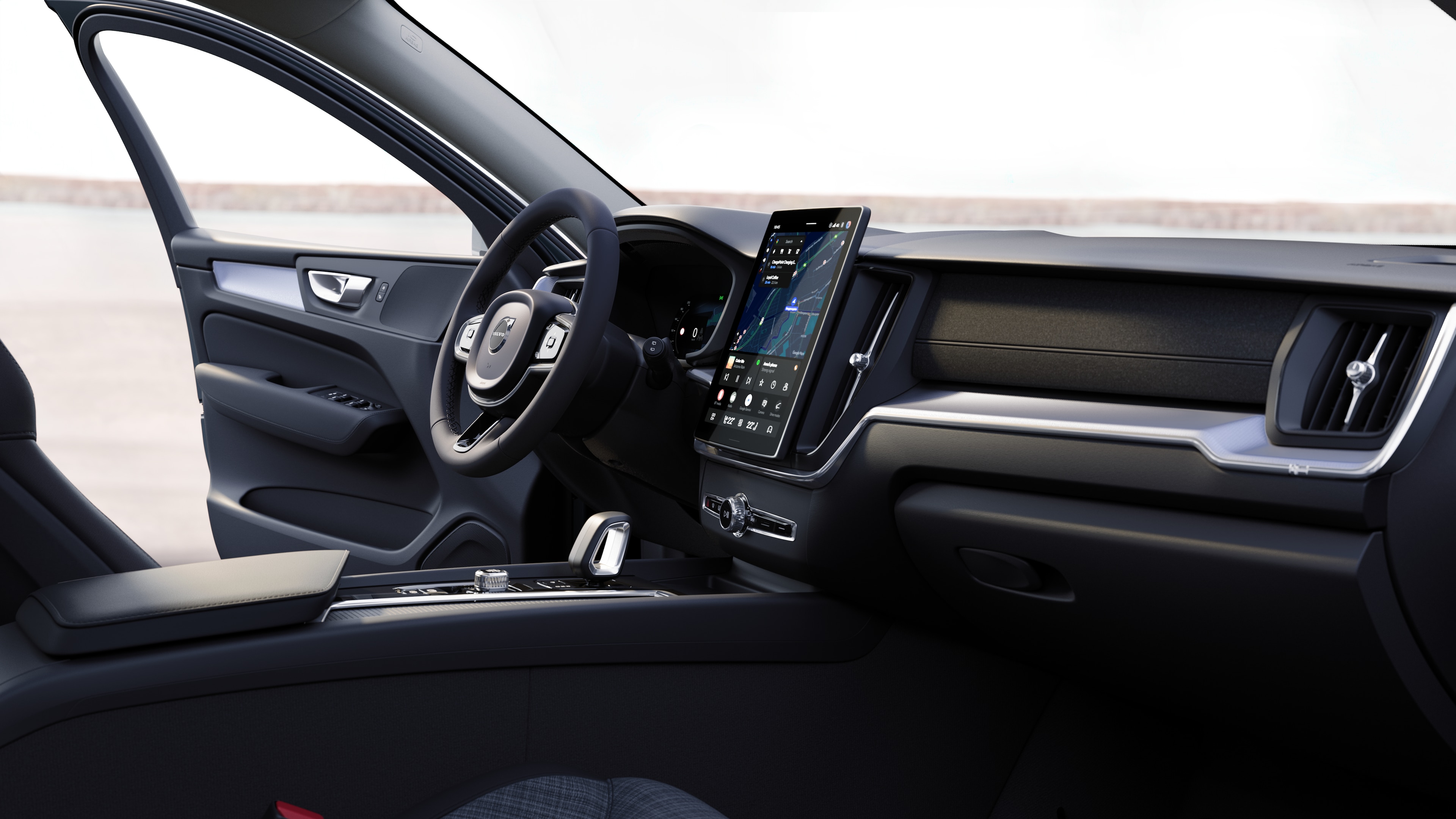 Intérieur d’une Volvo montrant le tableau de bord, le volant et la console centrale avec affichage numérique sur fond de route ouverte.