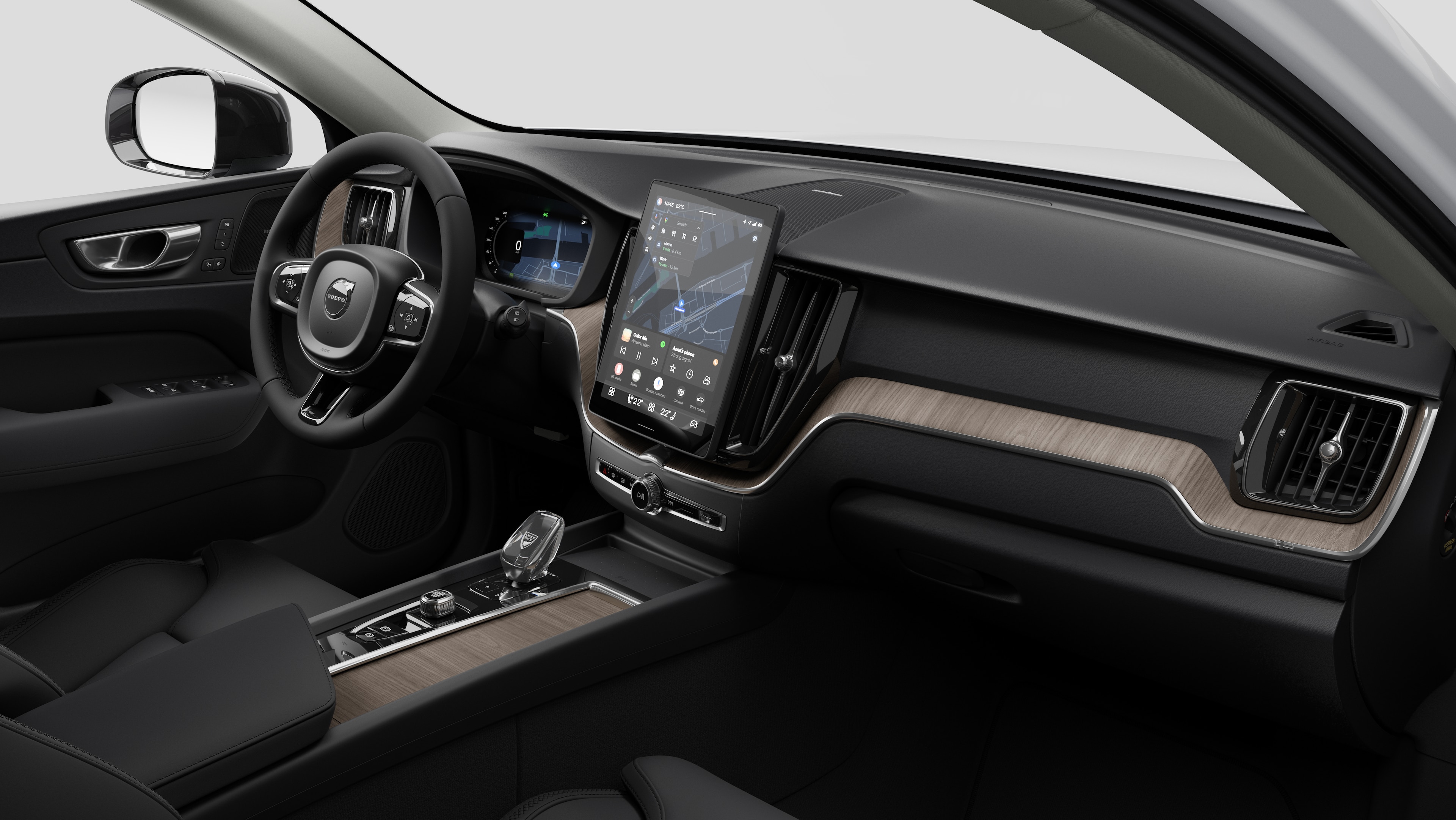 Volvo automašīnas salona skats, kurā redzams mērinstrumentu panelis, stūre, viduskonsole un digitālais displeja ekrāns vienkāršā studijas fonā.