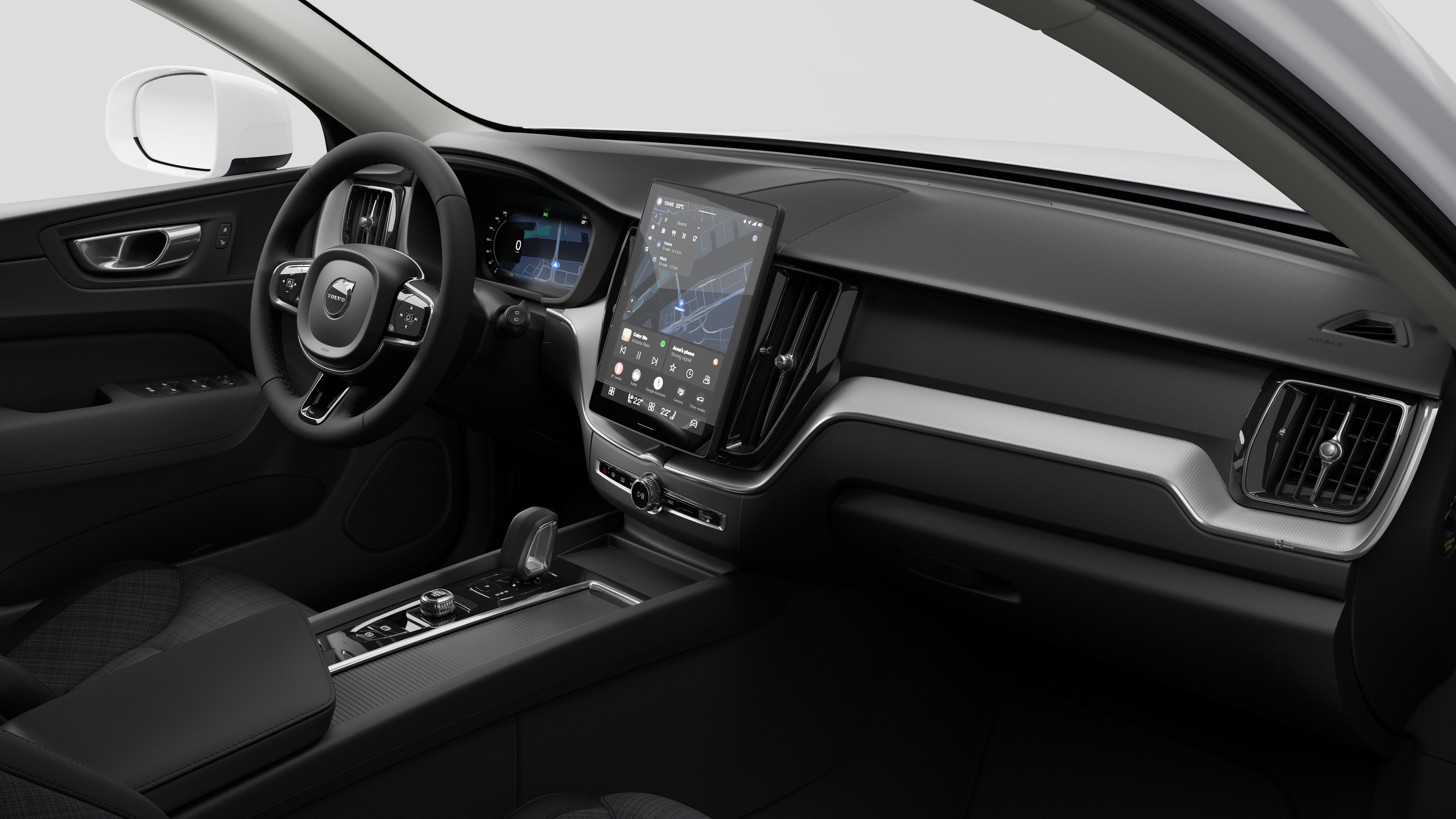Vista interna di un'auto Volvo che mostra il cruscotto, il volante, la console centrale e lo schermo digitale sullo sfondo di uno studio.