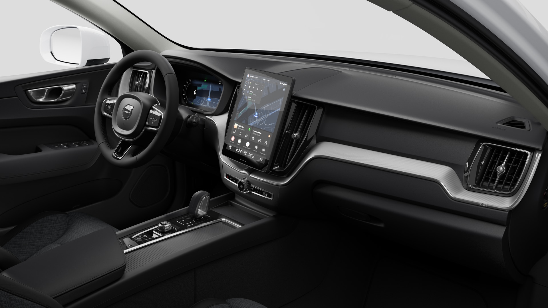 Vista interna di un'auto Volvo che mostra il cruscotto, il volante, la console centrale e lo schermo del display digitale in un semplice sfondo da studio.