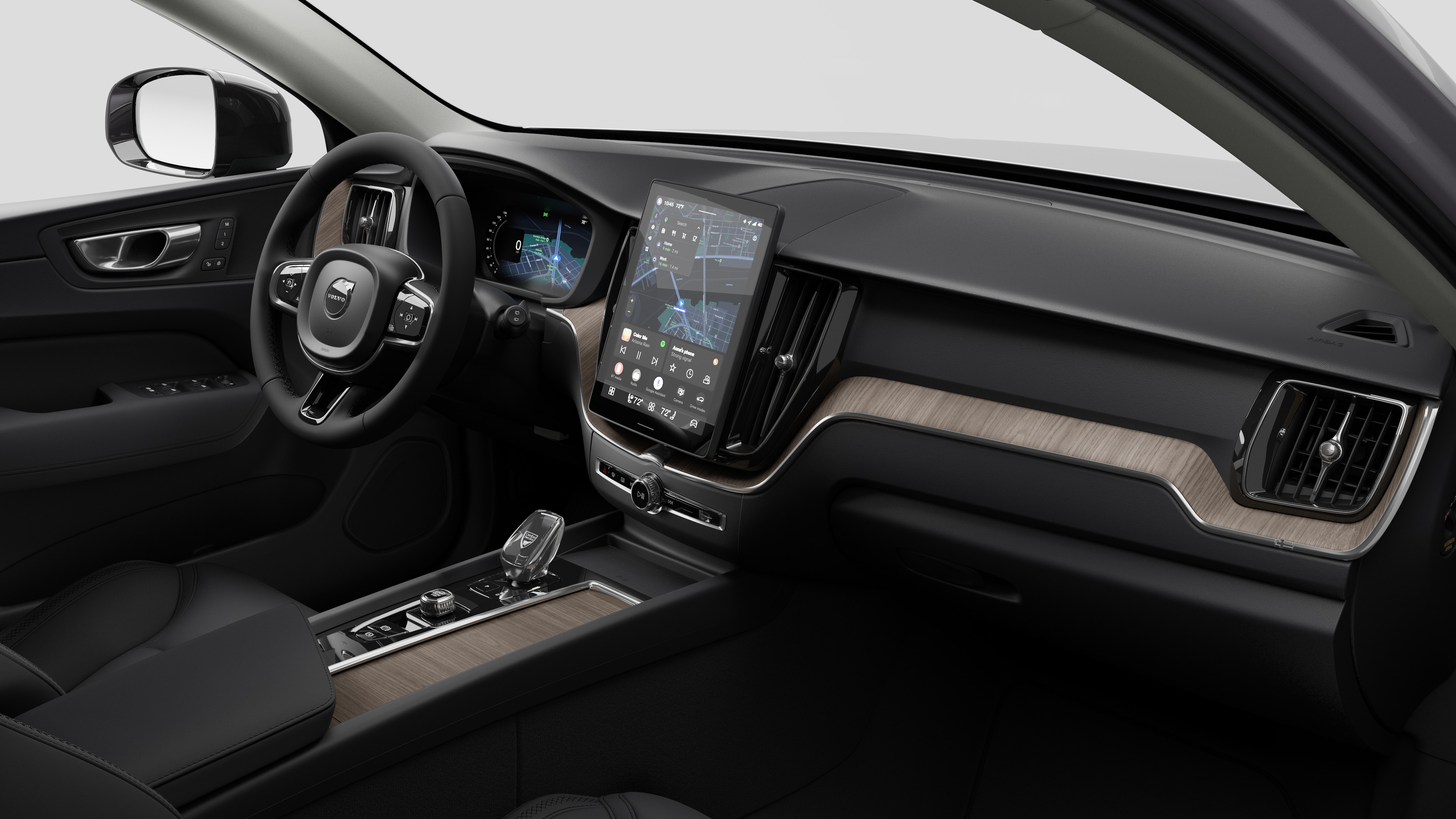 Interior view of a Volvo car showing the dashboard, steering wheel, center console, and digital display screen in a plain studio background.
