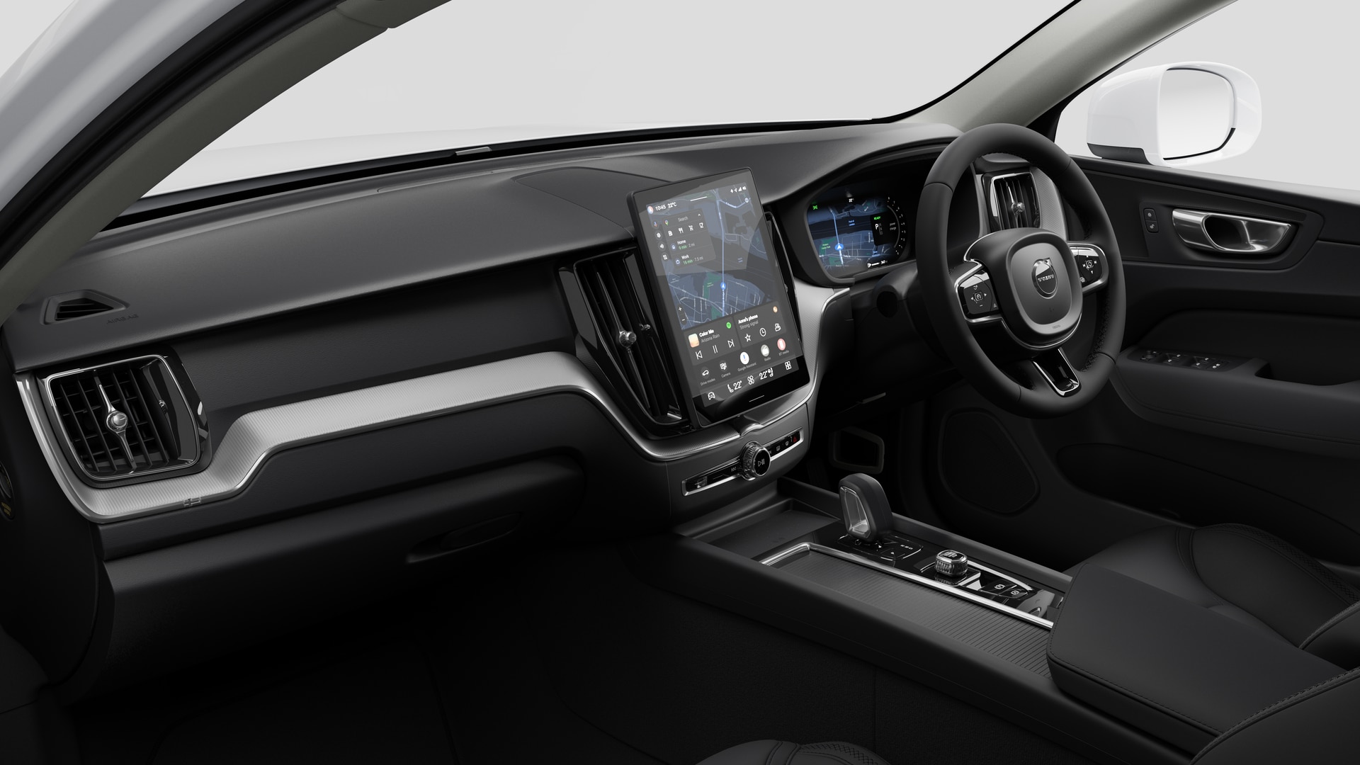 Interior view of a Volvo car showing the dashboard, steering wheel, centre console, and digital display screen in a plain studio background.