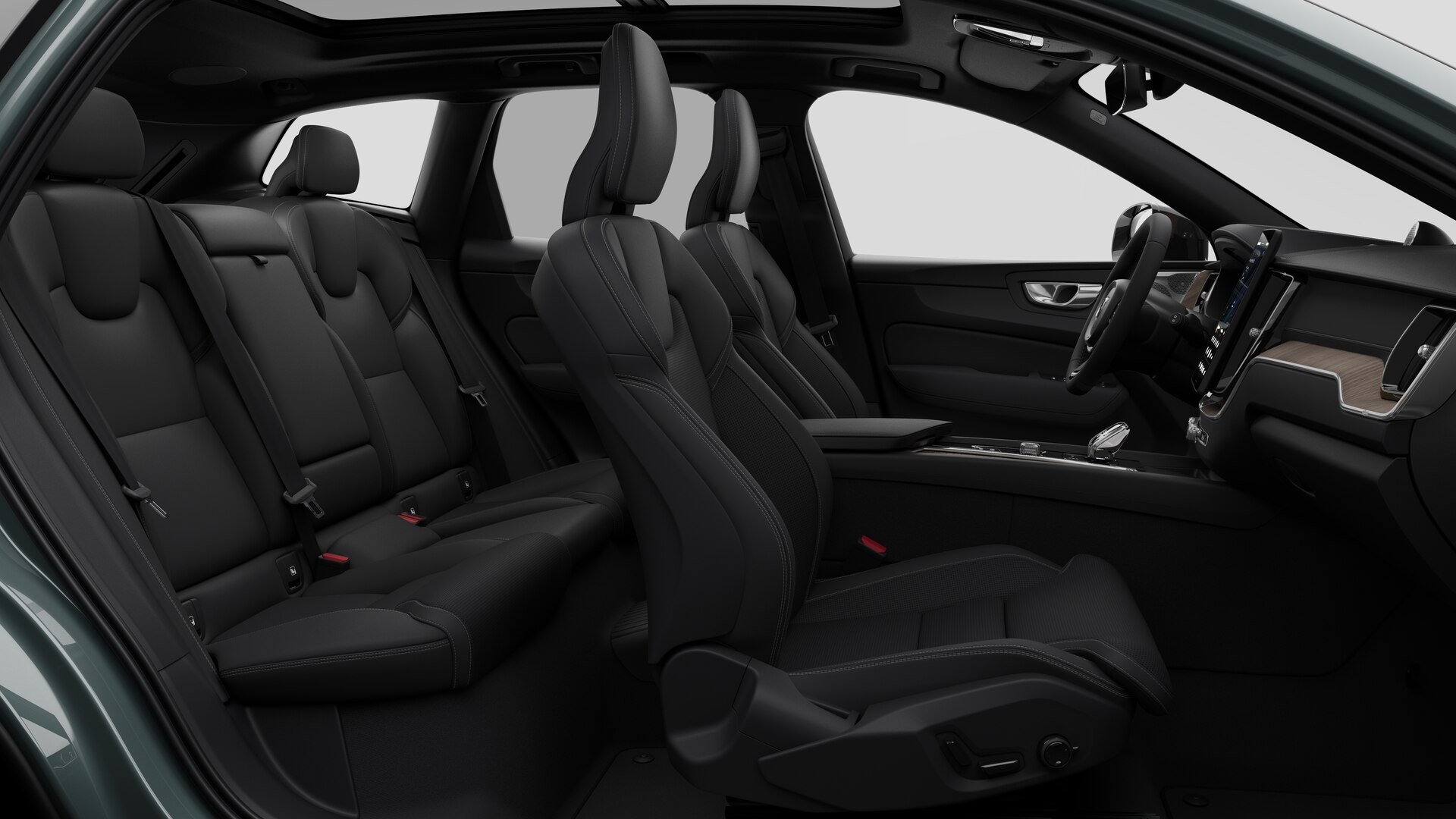 Vue latérale de l’intérieur d’une Volvo montrant les sièges avant, les sièges passager arrière, le volant, le tableau de bord et la console centrale, sur fond de studio.