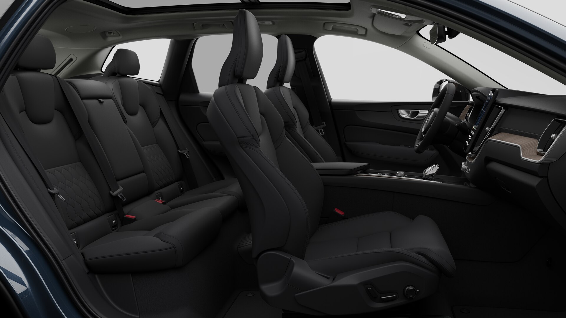 Vue latérale de l’intérieur d’une Volvo montrant les sièges avant, les sièges passager arrière, le volant, le tableau de bord et la console centrale, sur fond de studio.