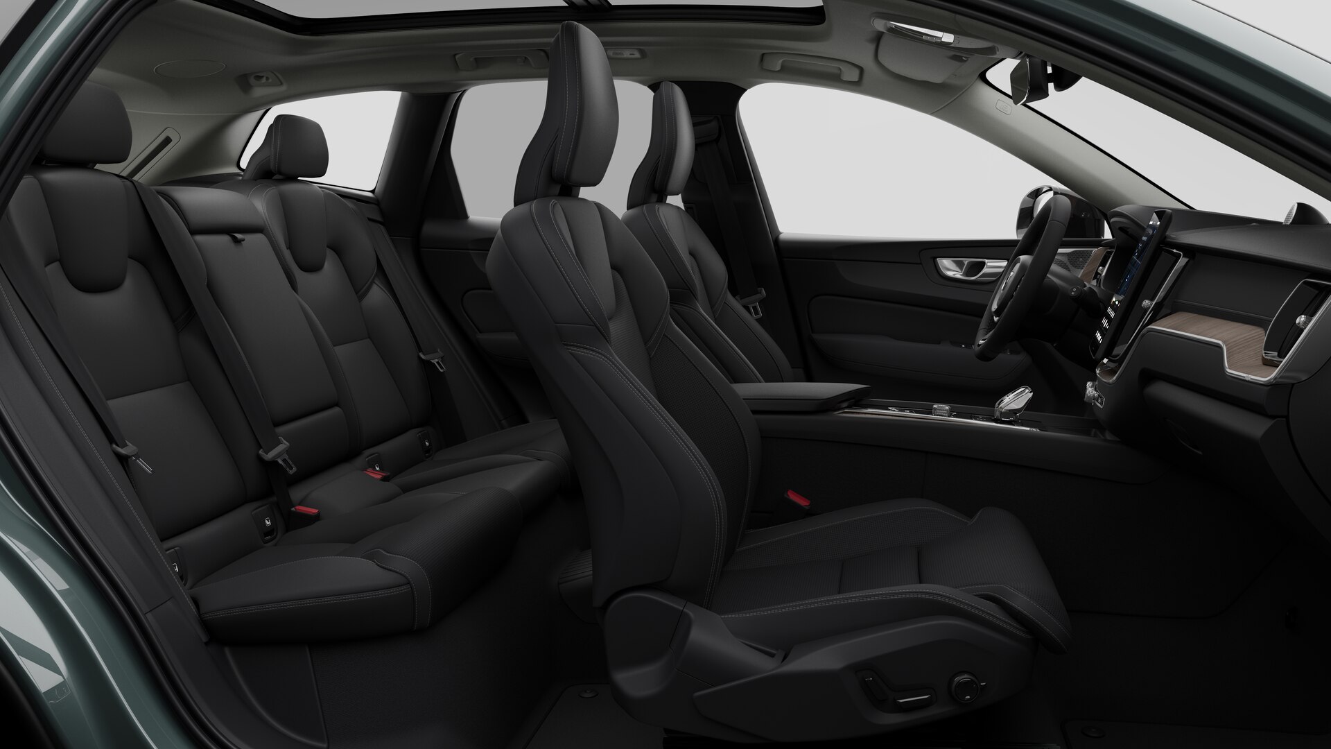 Vue latérale de l’intérieur d’une Volvo montrant les sièges avant, les sièges passager arrière, le volant, le tableau de bord et la console centrale, sur fond de studio.