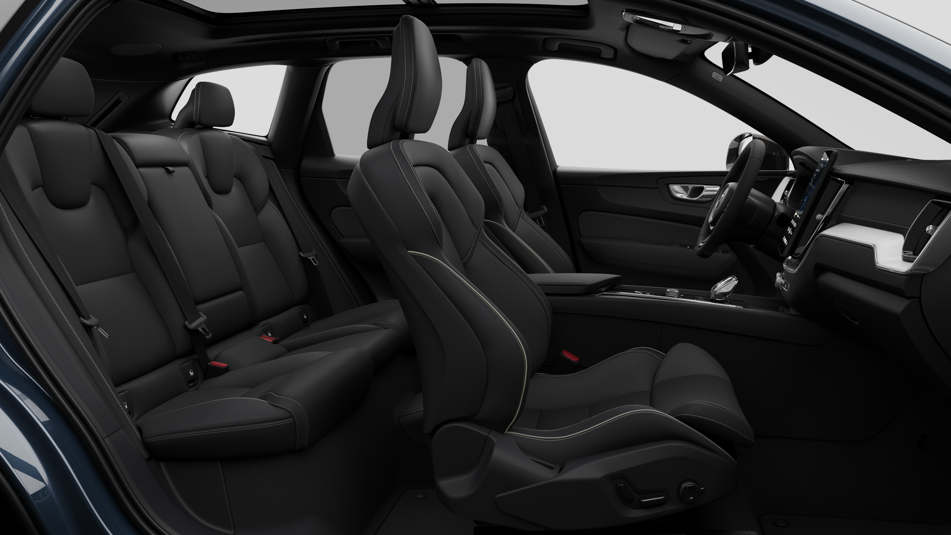 Vue latérale de l’intérieur d’une Volvo montrant les sièges avant, les sièges passager arrière, le volant, le tableau de bord et la console centrale, sur fond de studio.