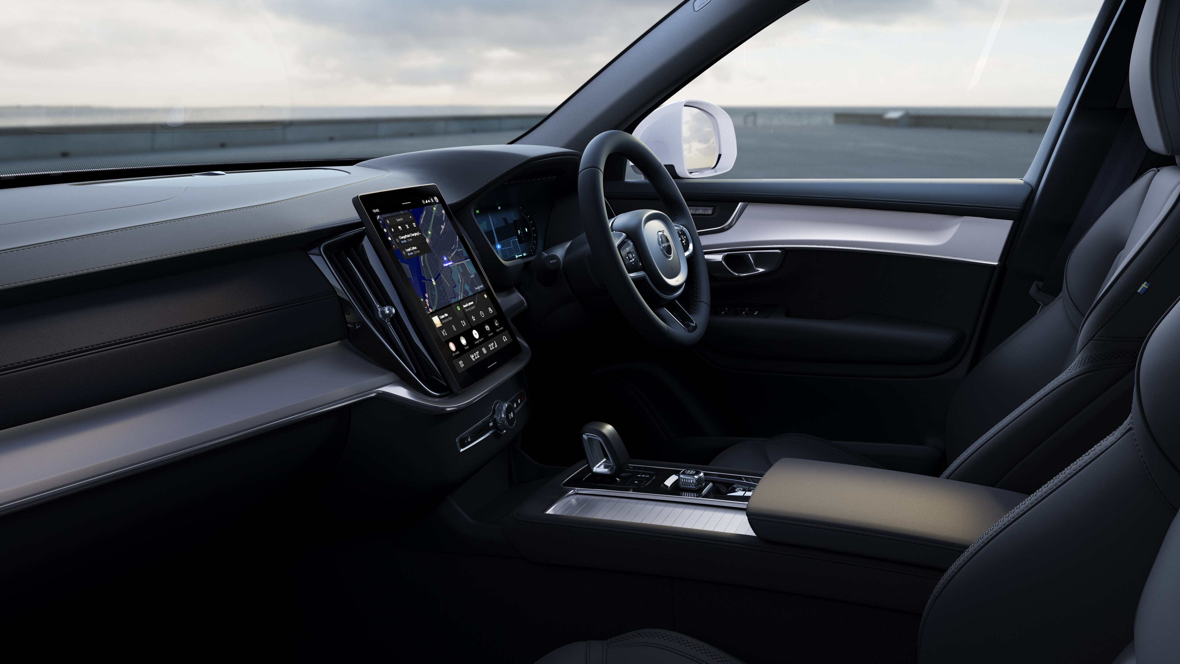 Volvo car interior showing dashboard, steering wheel, and center console with digital display in an open road background.