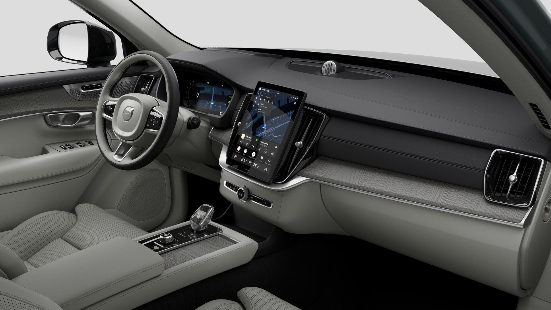 Vue intérieure d’une Volvo montrant le tableau de bord, le volant, la console centrale et l’écran d’affichage numérique sur un fond de studio uni.