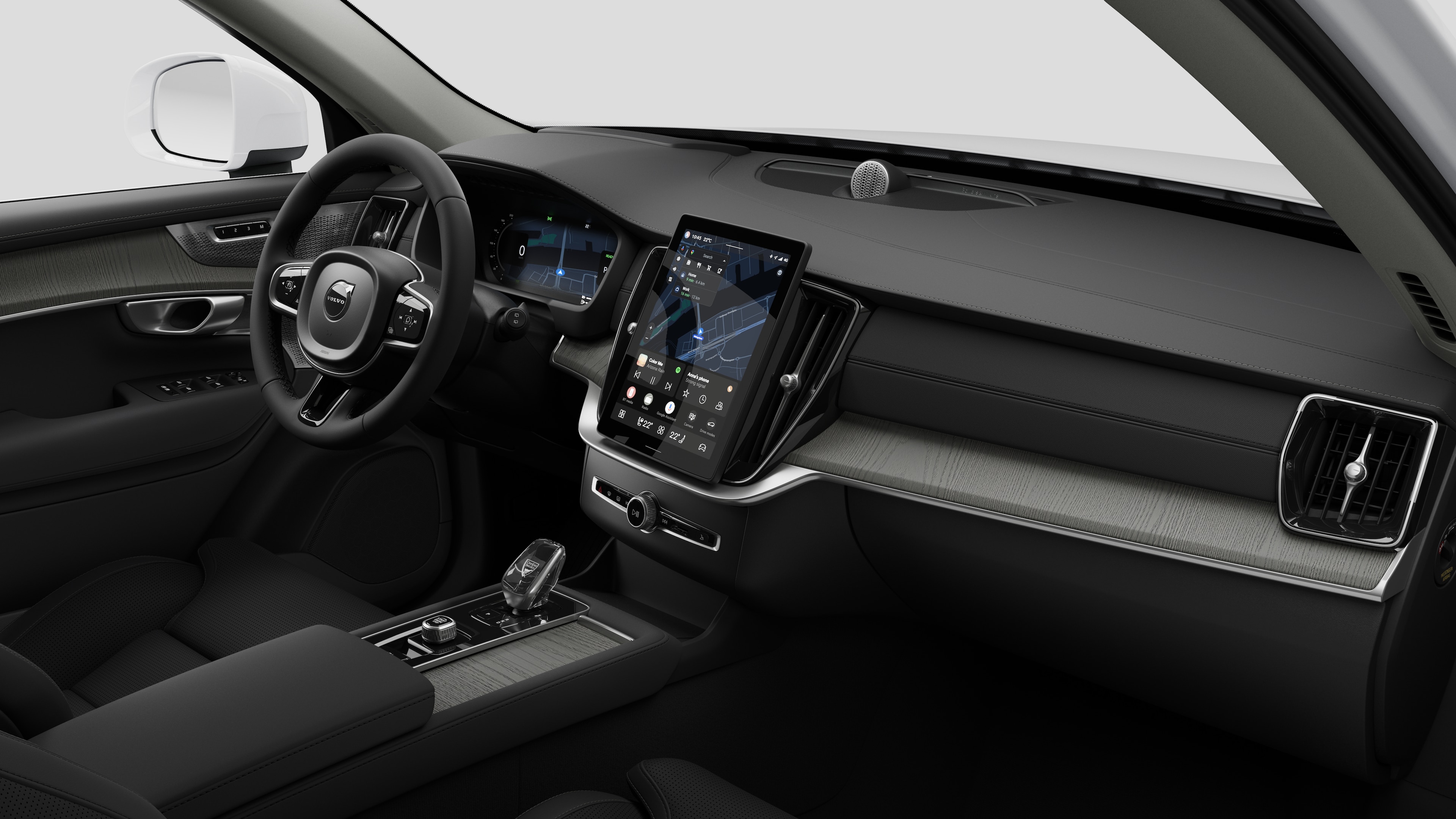 Interiörvy av en Volvobil som visar instrumentbrädan, ratten, mittkonsolen och den digitala skärmen i en vanlig studiobakgrund.