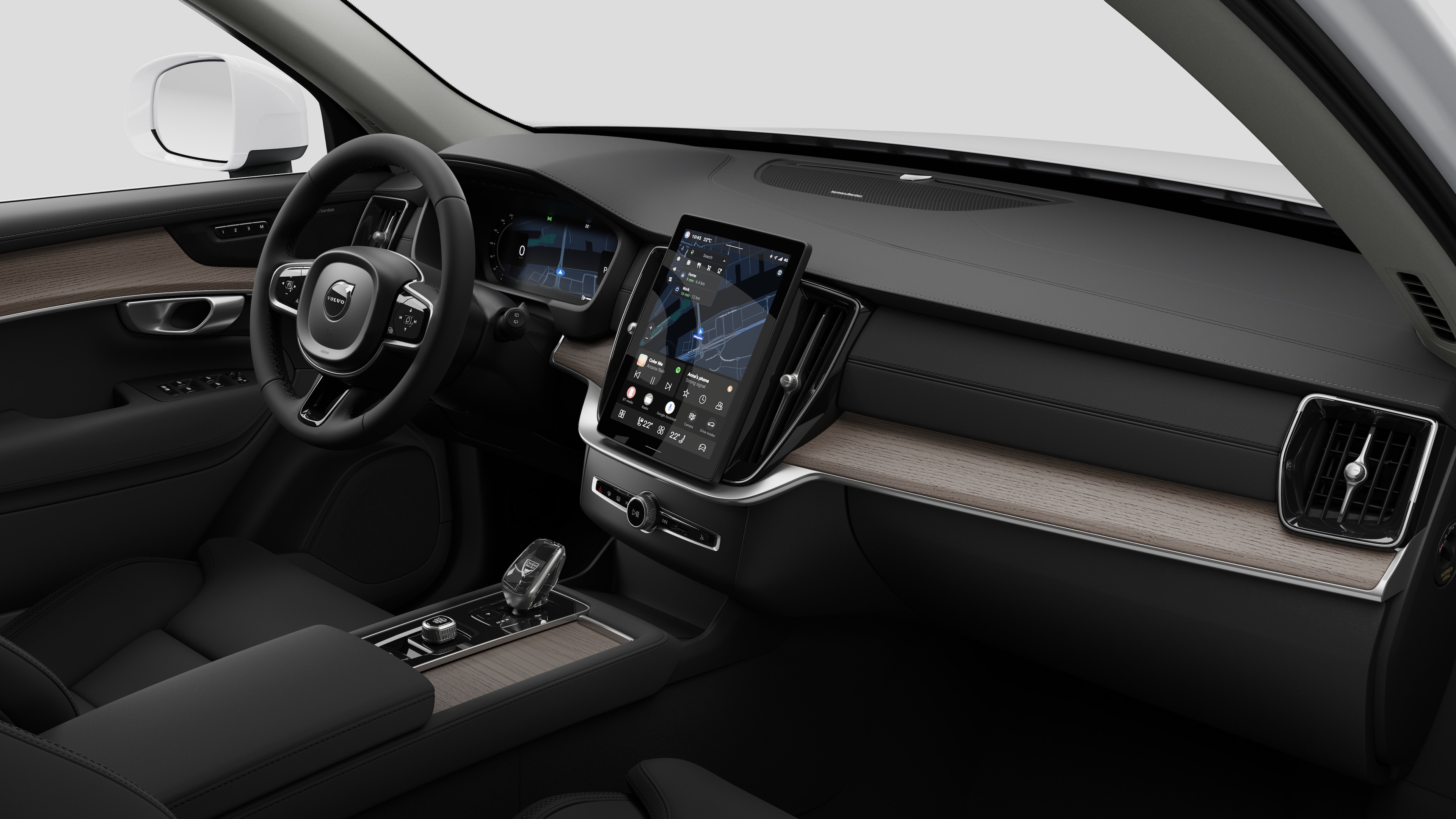 "Volvo" automobilio salono vaizdas, kuriame rodomas prietaisų skydelis, vairas, centrinė konsolė ir skaitmeninis ekranas paprastame studijos fone.