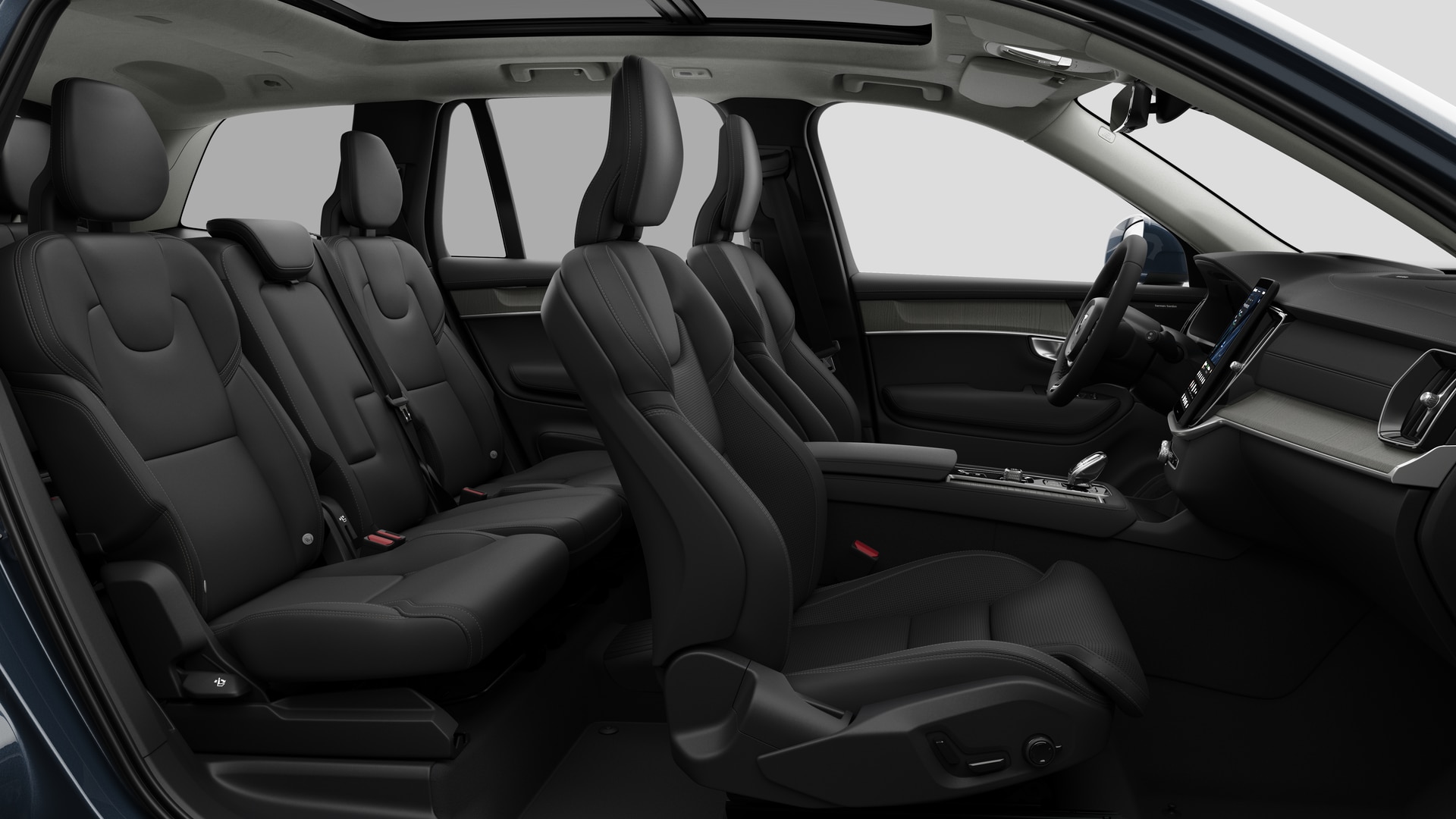Vue latérale de l’intérieur d’une Volvo montrant les sièges avant, les sièges passager arrière, le volant, le tableau de bord et la console centrale, sur fond de studio.