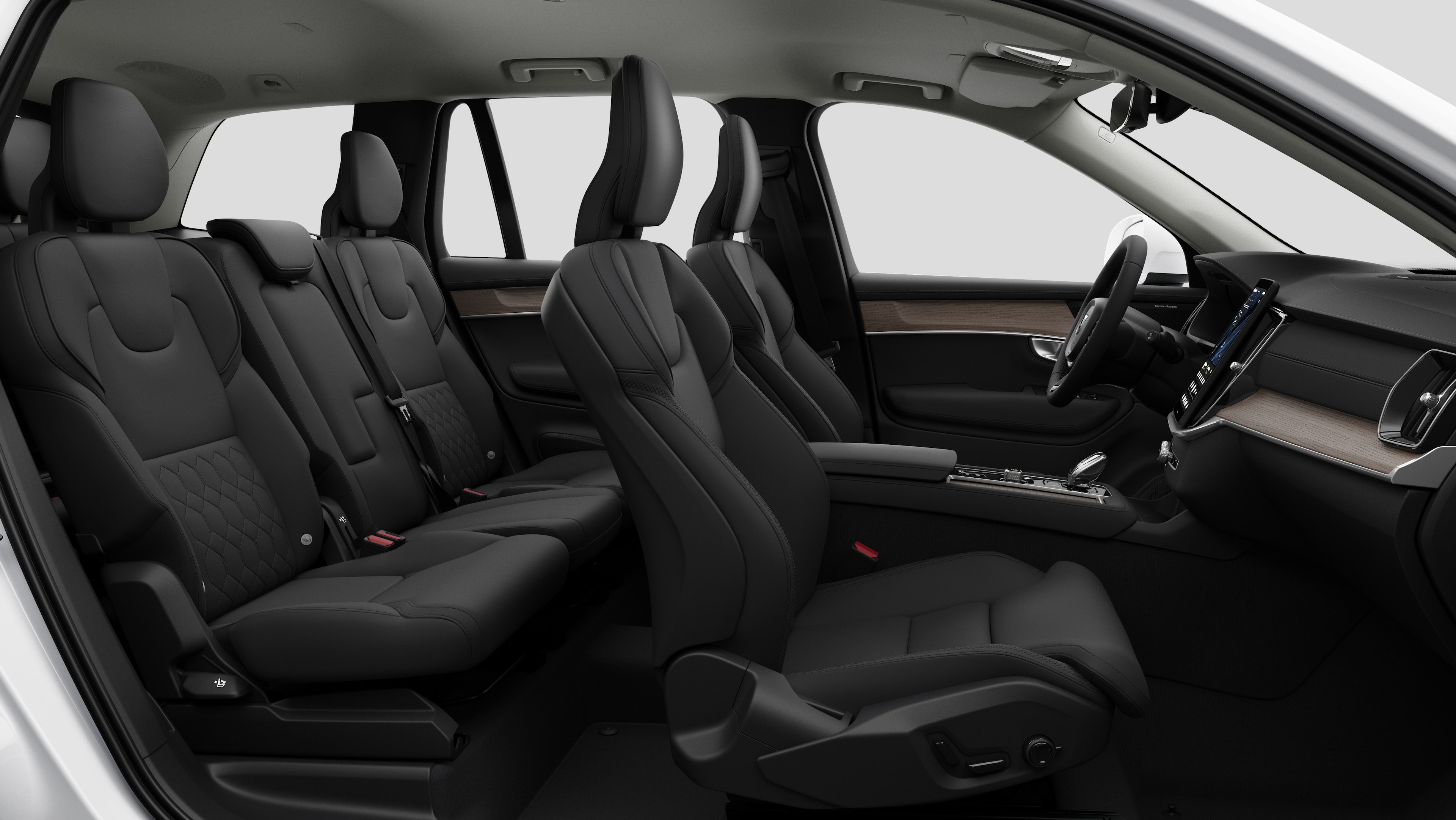 "Volvo" automobilio salono šoninis vaizdas, kuriame pavaizduotos priekinės sėdynės, galinės keleivio sėdynės, vairas, prietaisų skydelis ir centrinė konsolė – sukurtas paprastame studijos fone.