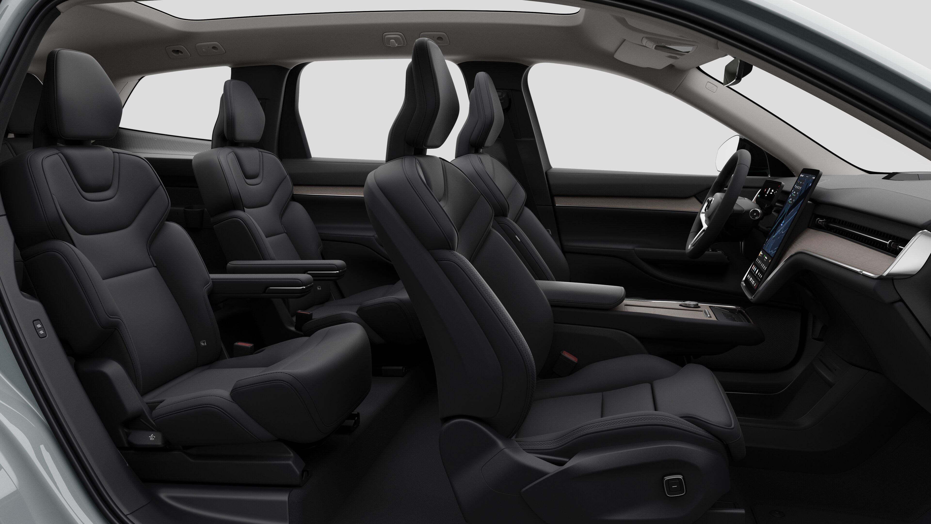 Volvo -auton sisätilojen sivunäkymä, jossa näkyy etuistuimet, takamatkustajan istuimet, ohjauspyörä, kojelauta ja keskikonsoli studiotaustaa vasten.
