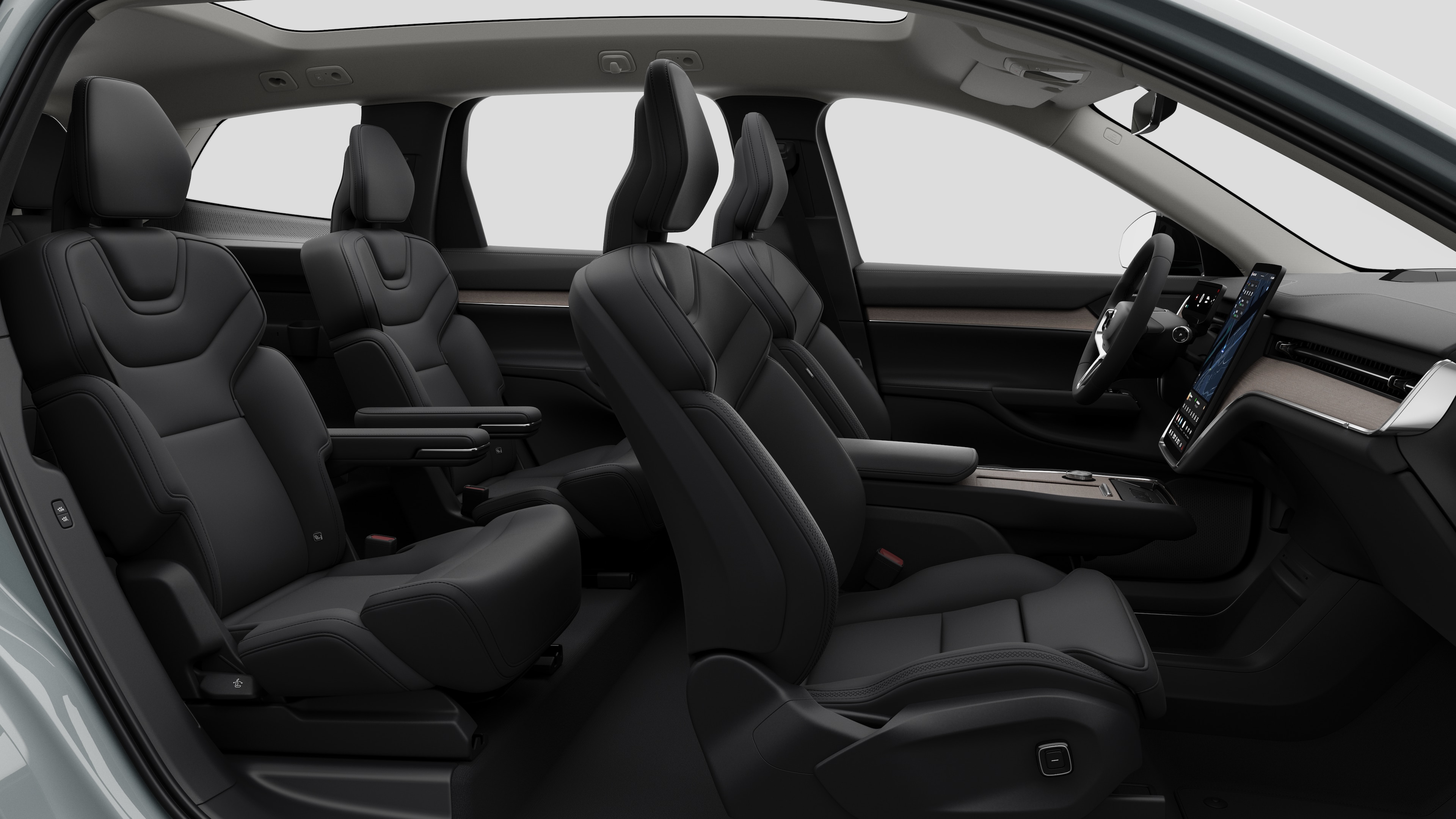 Volvo -auton sisätilojen sivunäkymä, jossa näkyy etuistuimet, takamatkustajan istuimet, ohjauspyörä, kojelauta ja keskikonsoli studiotaustaa vasten.