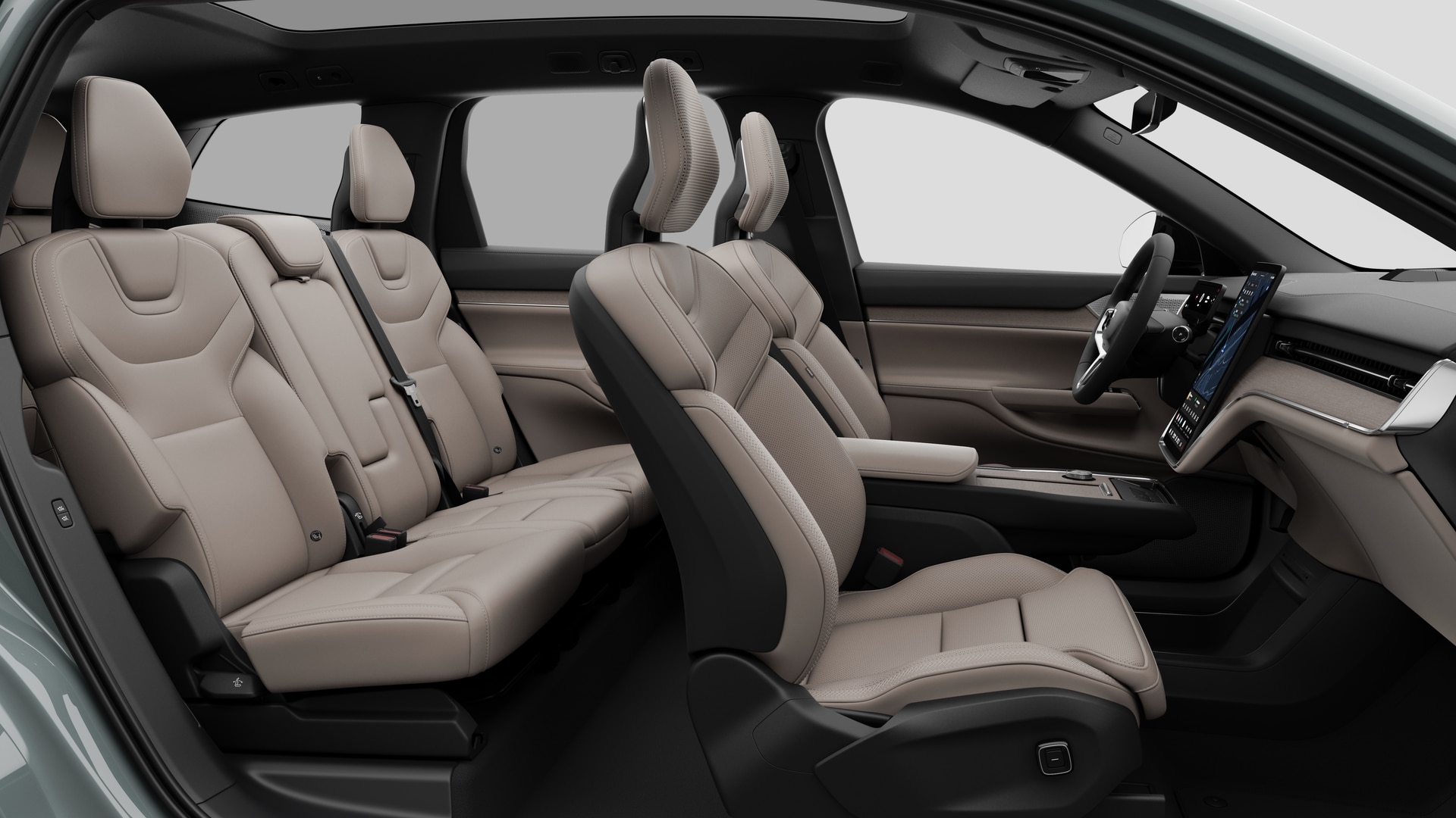 Vue latérale de l’intérieur d’une Volvo montrant les sièges avant, les sièges passager arrière, le volant, le tableau de bord et la console centrale, sur fond de studio.