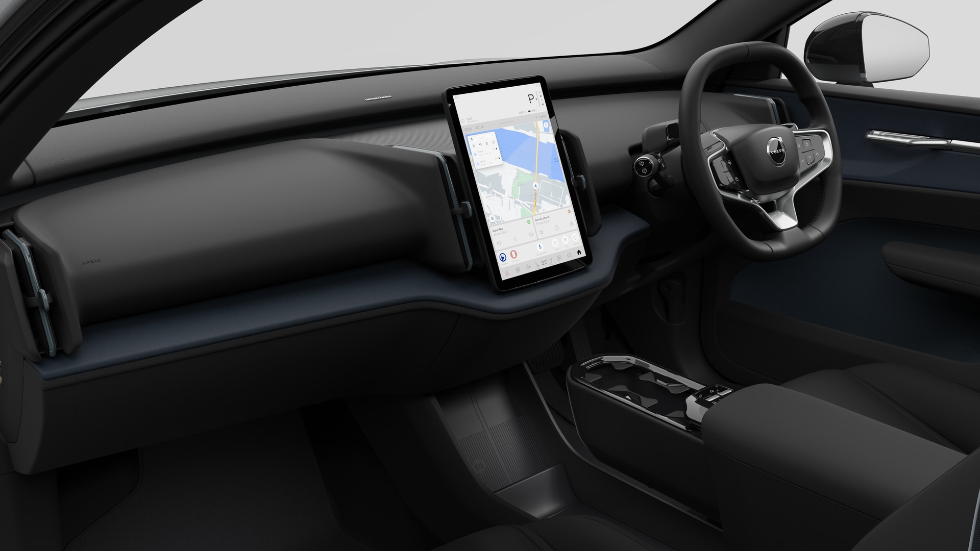 Interior view of a Volvo car showing the dashboard, steering wheel, centre console, and digital display screen in a plain studio background.