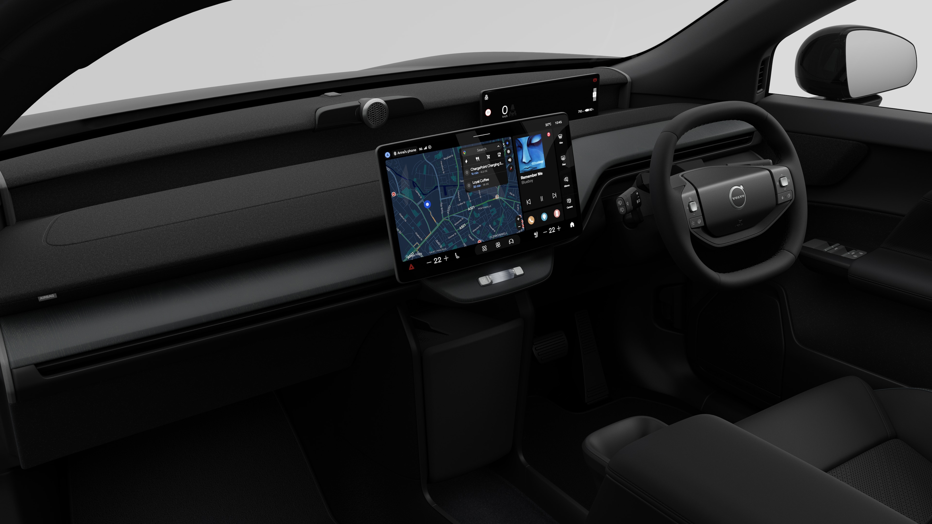 Interior view of a Volvo car showing the dashboard, steering wheel, center console, and digital display screen in a plain studio background.
