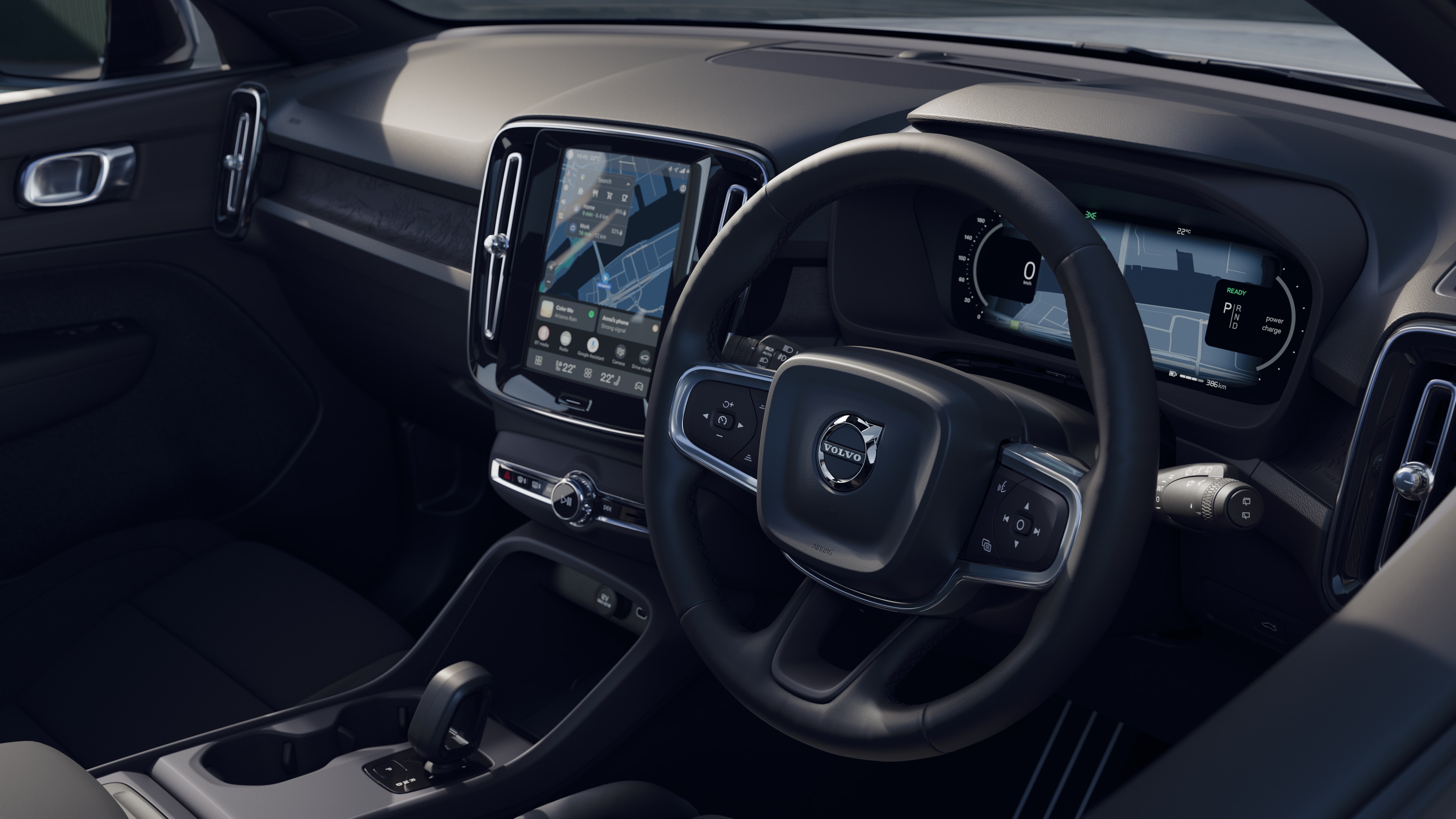 Volvo car interior showing dashboard, steering wheel, and center console with digital display in an open road background.