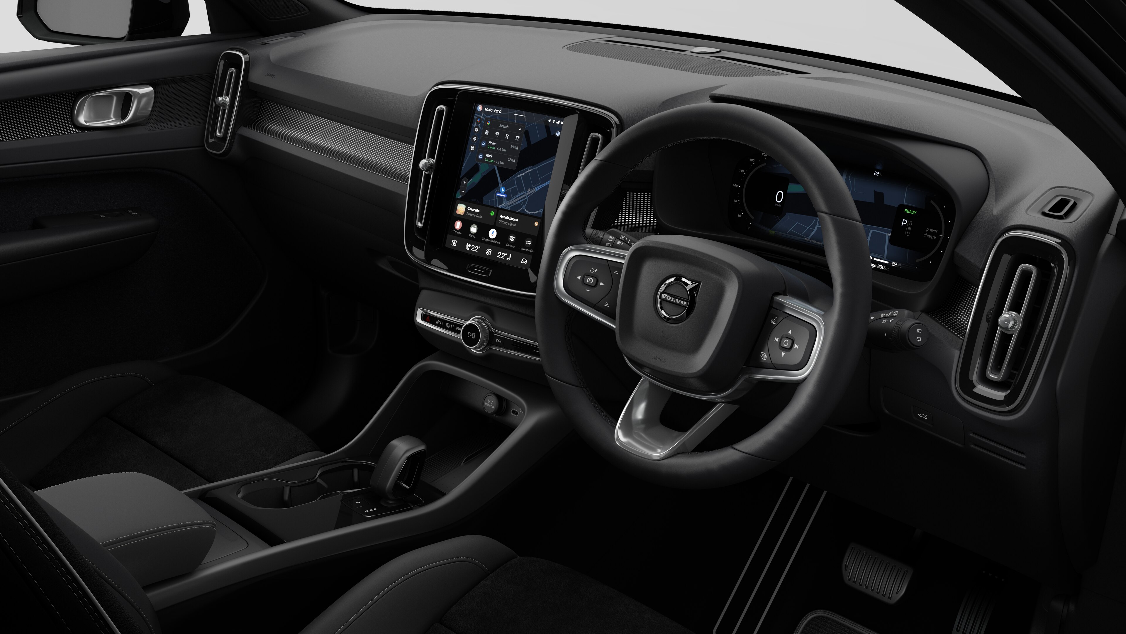 Interior view of a Volvo car showing the dashboard, steering wheel, center console, and digital display screen in a plain studio background.