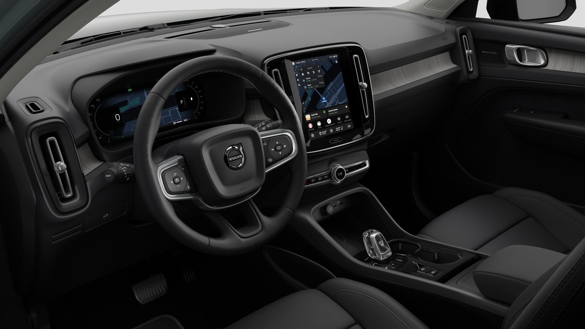 Vue intérieure d’une Volvo montrant le tableau de bord, le volant, la console centrale et l’écran d’affichage numérique sur un fond de studio uni.
