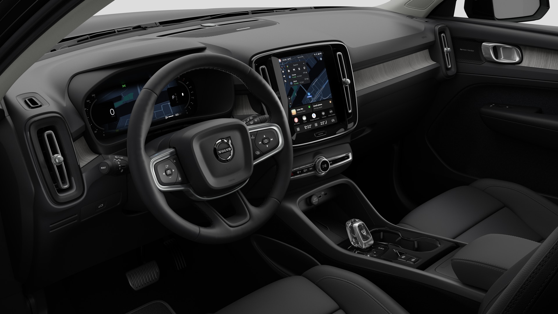 Vue intérieure d’une Volvo montrant le tableau de bord, le volant, la console centrale et l’écran d’affichage numérique sur un fond de studio uni.