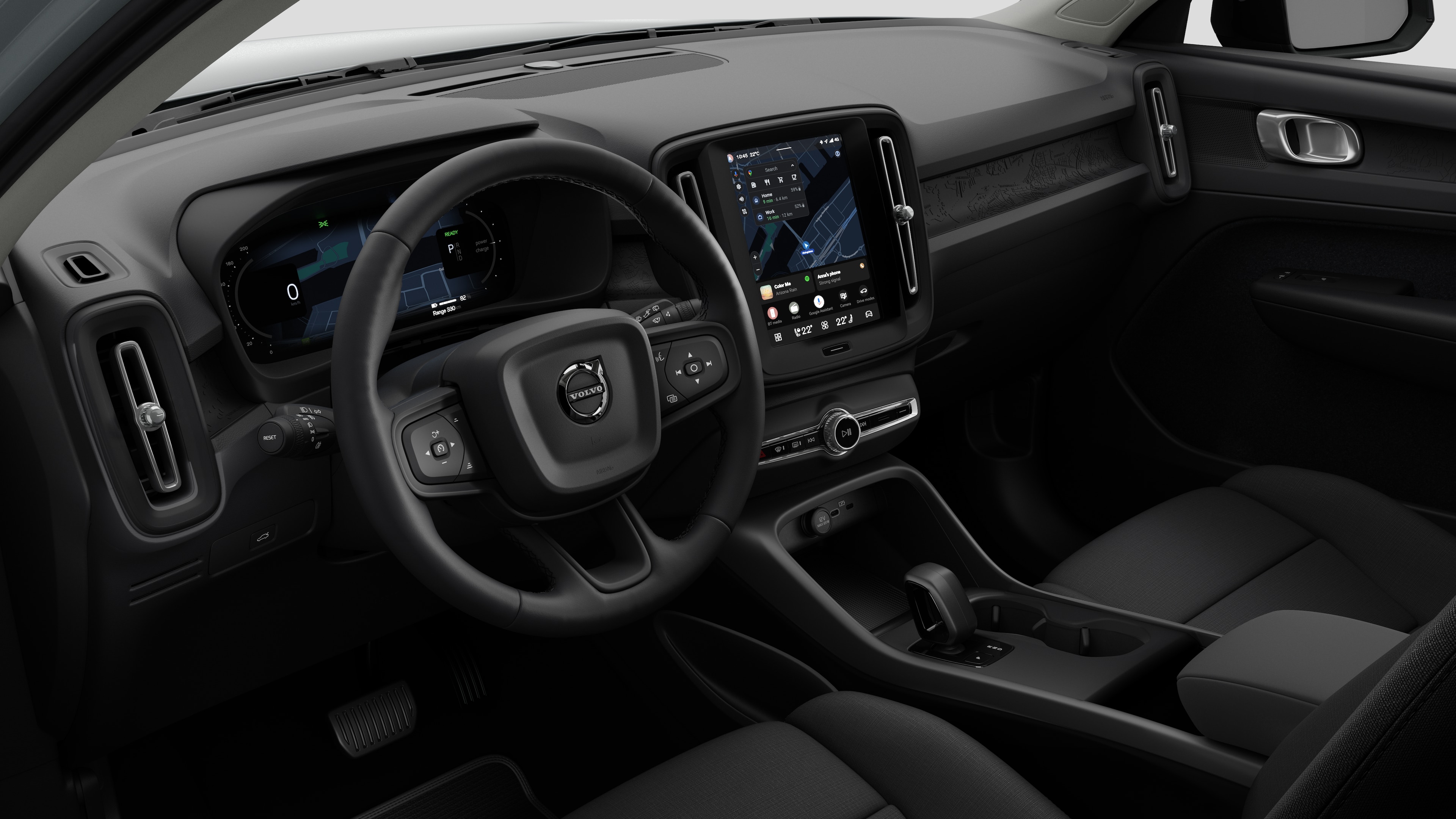 Vue intérieure d’une Volvo montrant le tableau de bord, le volant, la console centrale et l’écran d’affichage numérique dans un fond de studio uni.