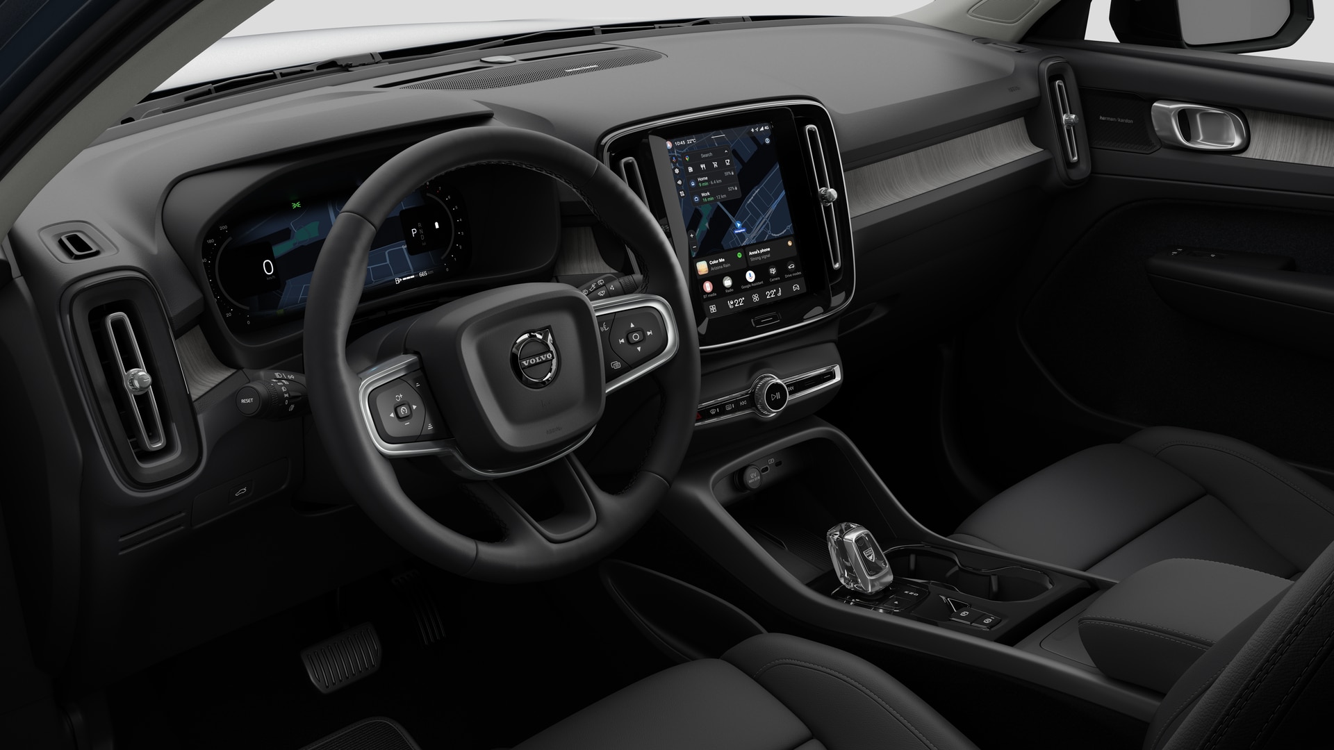 Vue intérieure d’une Volvo montrant le tableau de bord, le volant, la console centrale et l’écran d’affichage numérique sur un fond de studio uni.
