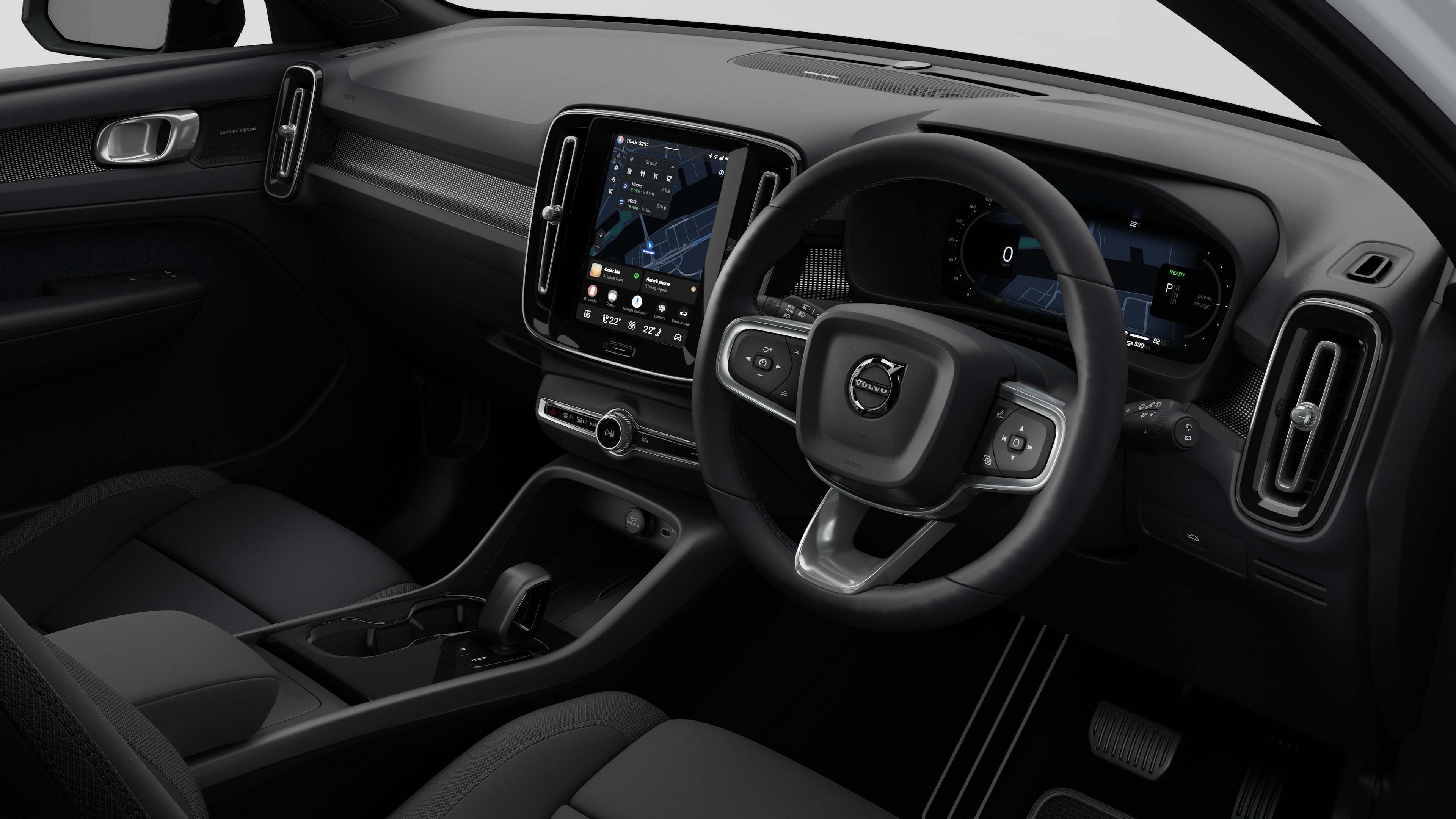 Interior view of a Volvo car showing the dashboard, steering wheel, center console, and digital display screen in a plain studio background.