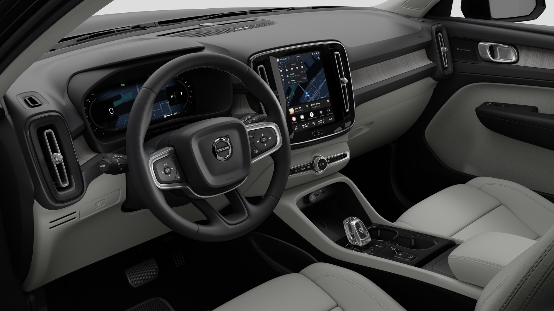 Vue intérieure d’une Volvo montrant le tableau de bord, le volant, la console centrale et l’écran d’affichage numérique sur un fond de studio uni.