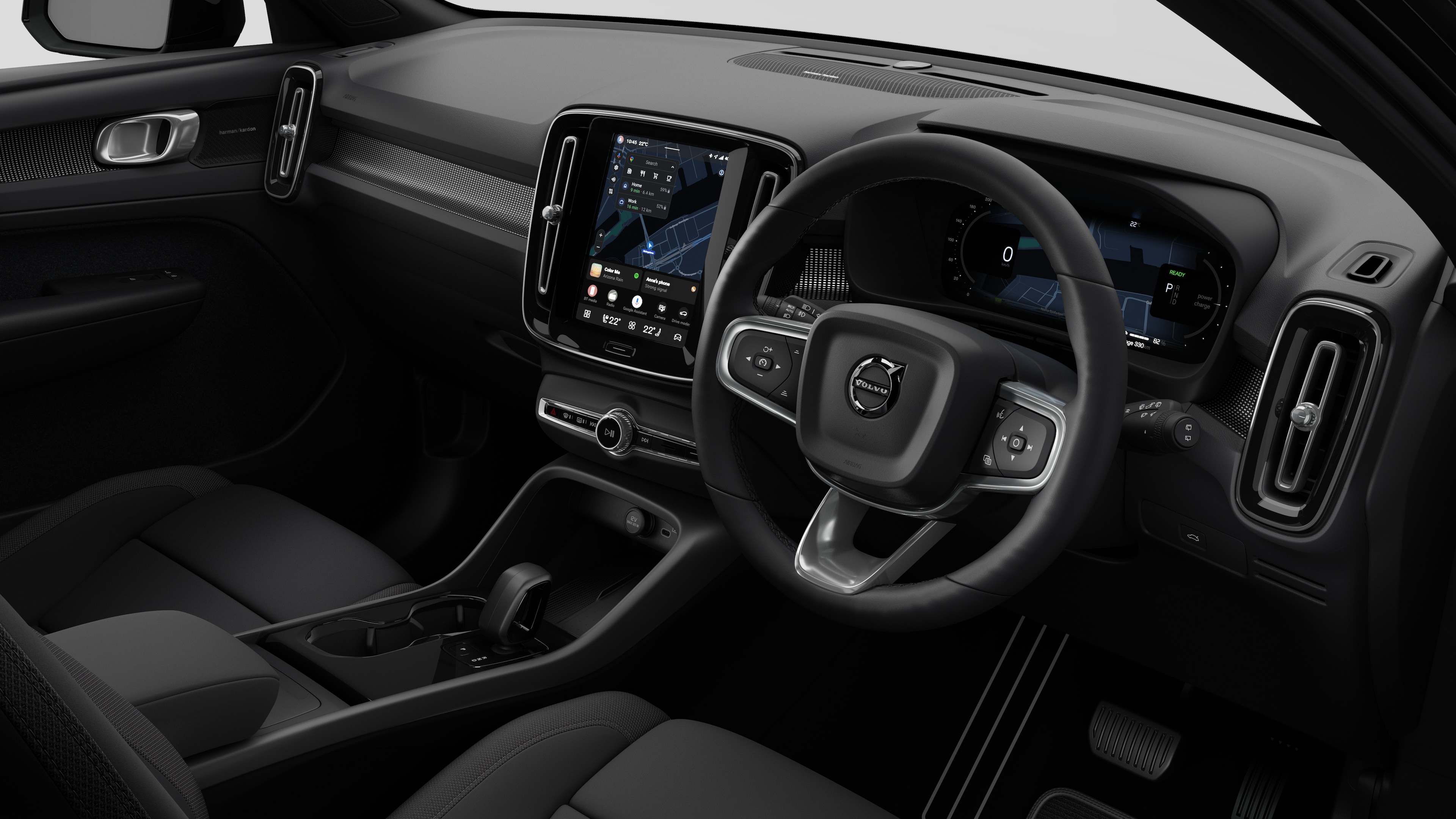 Interior view of a Volvo car showing the dashboard, steering wheel, center console, and digital display screen in a plain studio background.